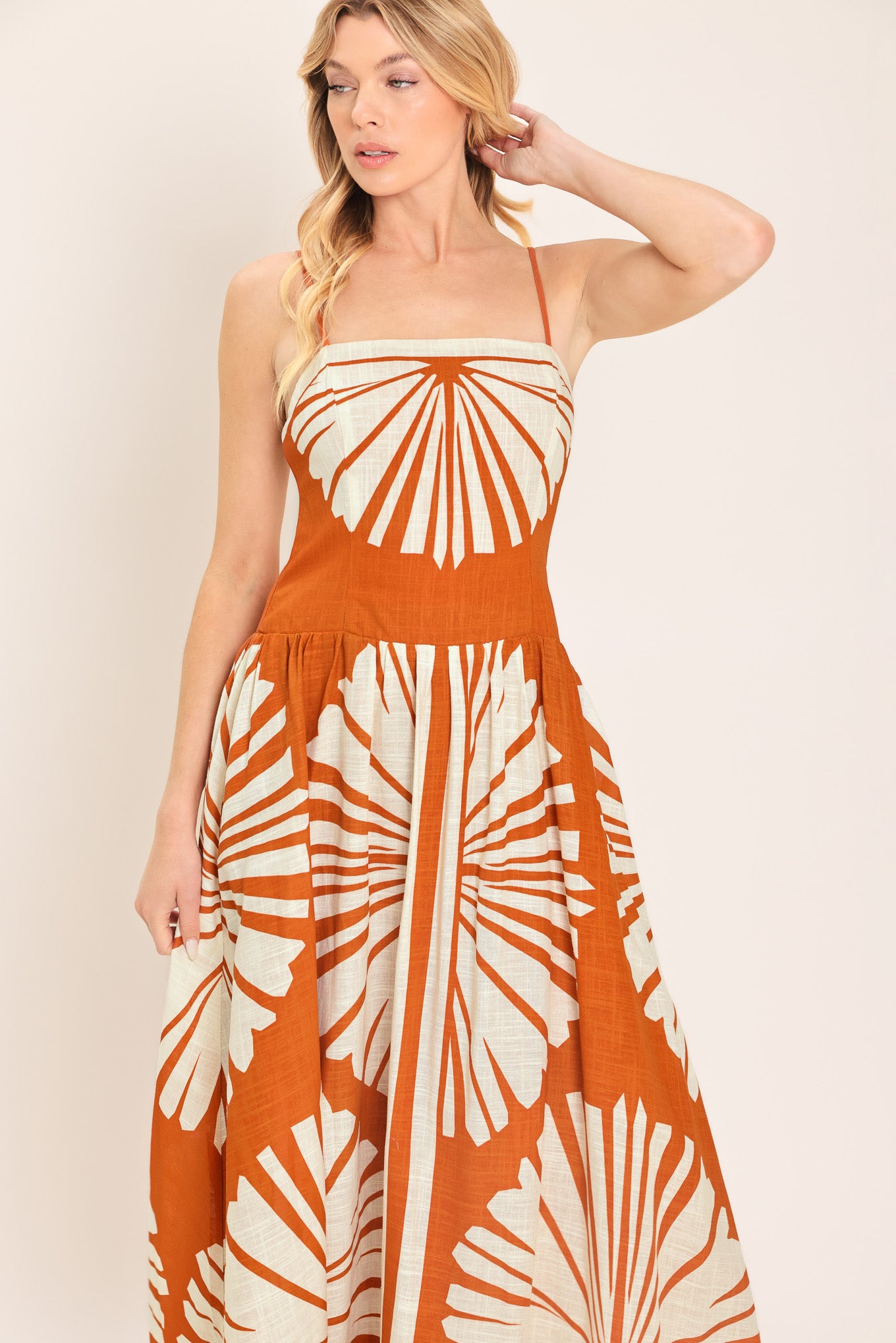Woman wearing a maxi dress with an almond orange and white pattern | Flying Tomato
