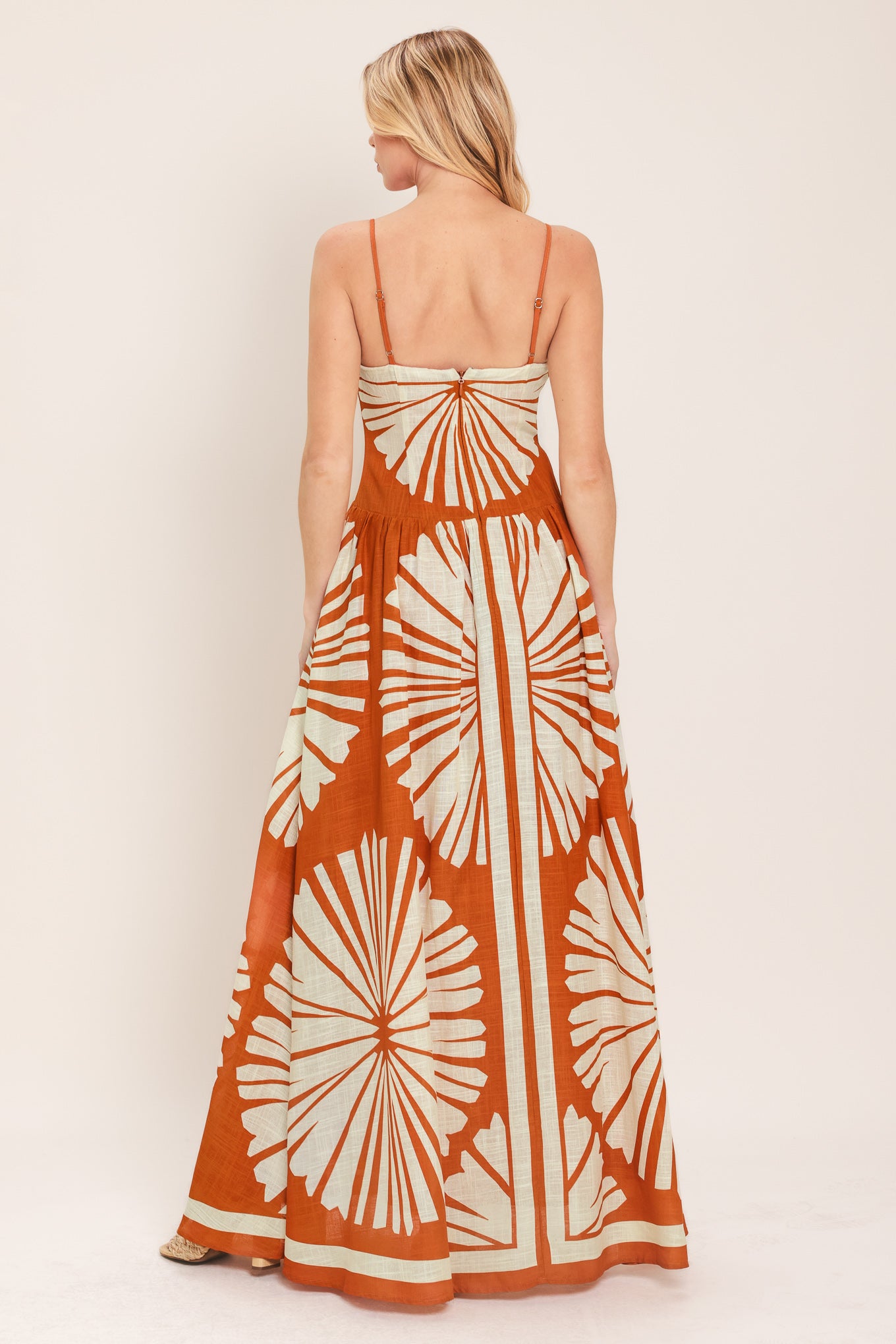 Woman wearing a maxi dress with an almond orange and white pattern | Flying Tomato