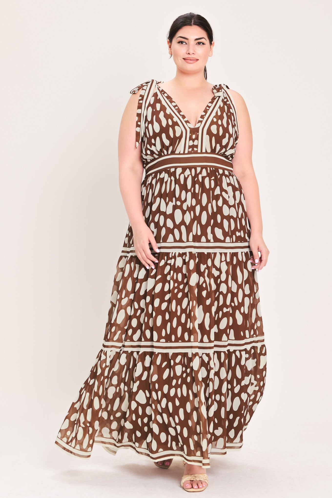Woman wearing a brown and beige patterned dress on a white background