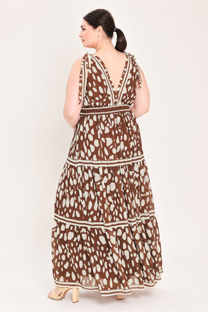 Woman wearing a brown and white patterned dress on a white background