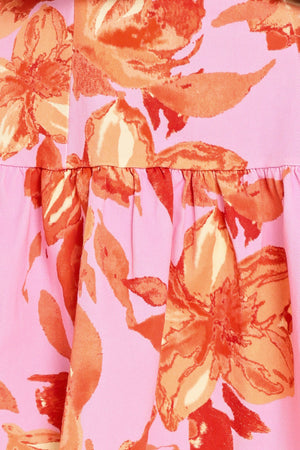 Woman wearing a lavender and coral floral printed mini dress featuring sweetheart neckline, short puff sleeve, ruffle hem and back zipper closure | Flying Tomato