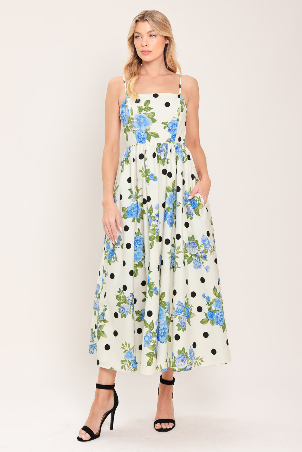 Woman wearing a floral and polka dot dress on a white background