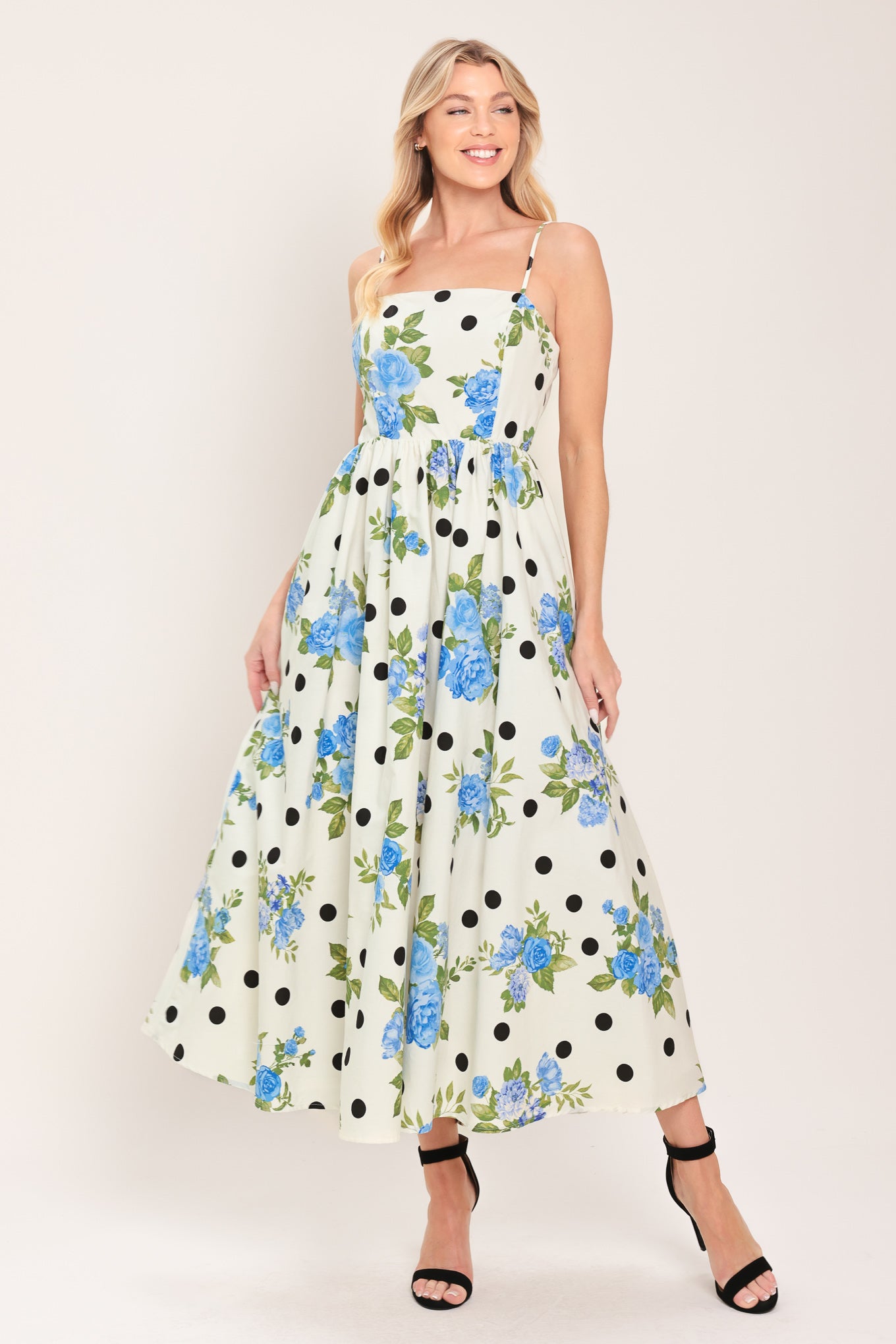 Woman wearing a floral and polka dot dress on a white background