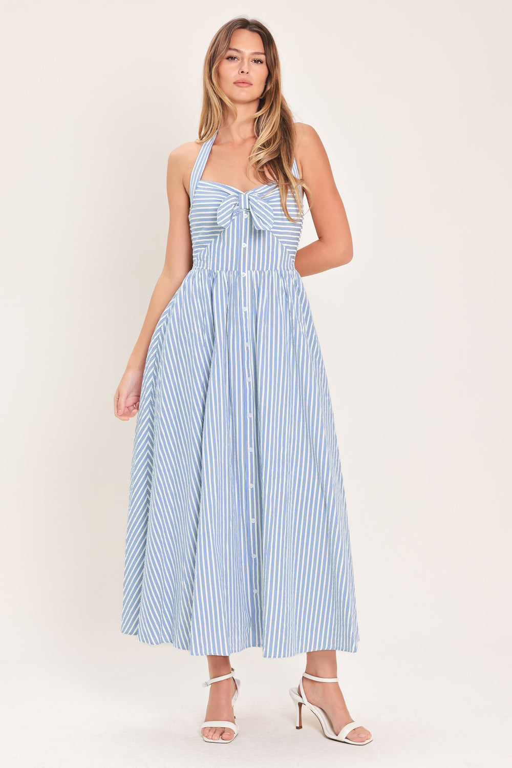 Woman wearing a striped woven midi dress featuring sweetheart halter neckline with back tie, front tie and button down, bare back with smocked back bodice | Flying Tomato