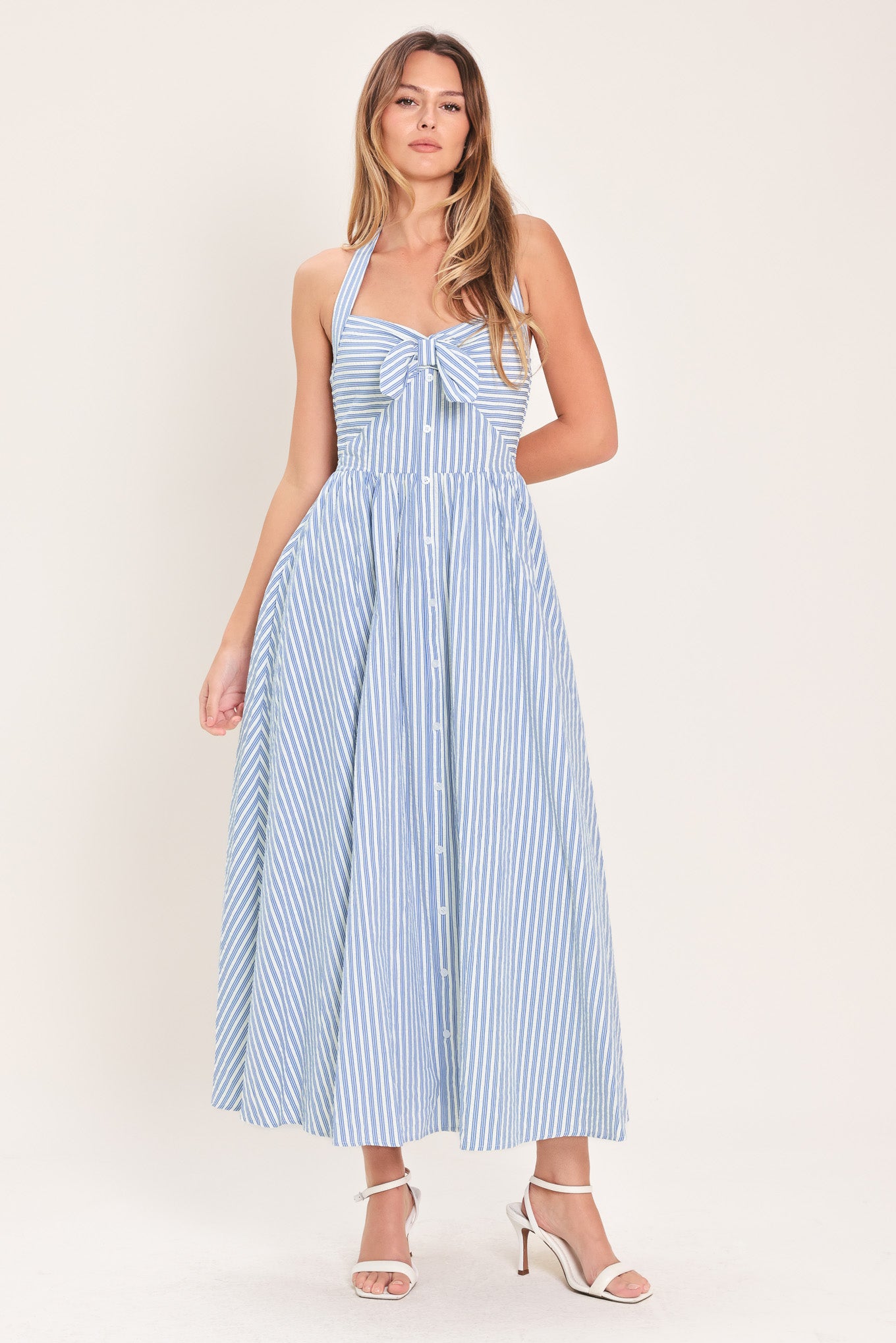 Woman wearing a striped woven midi dress featuring sweetheart halter neckline with back tie, front tie and button down, bare back with smocked back bodice | Flying Tomato