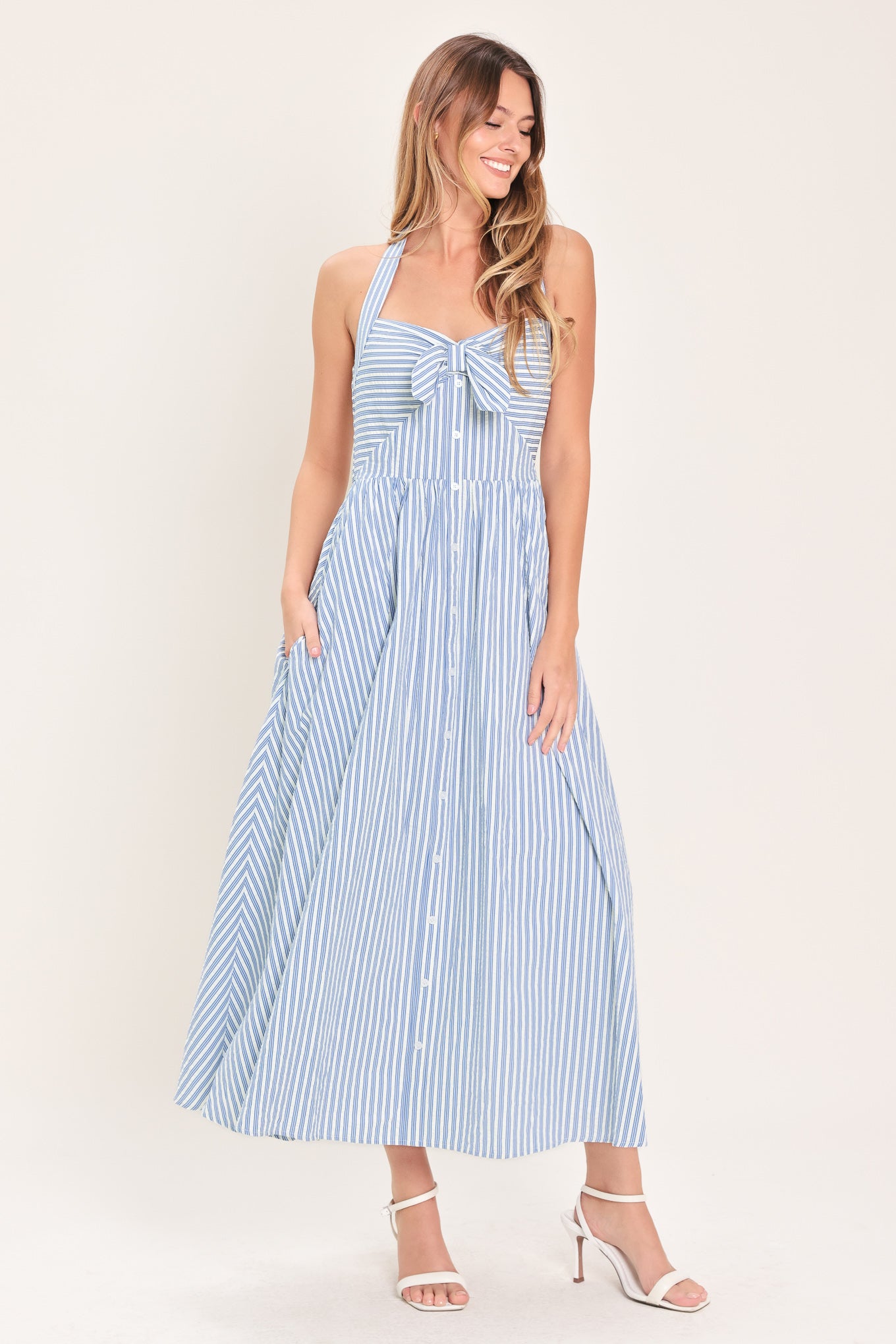 Woman wearing a striped woven midi dress featuring sweetheart halter neckline with back tie, front tie and button down, bare back with smocked back bodice | Flying Tomato