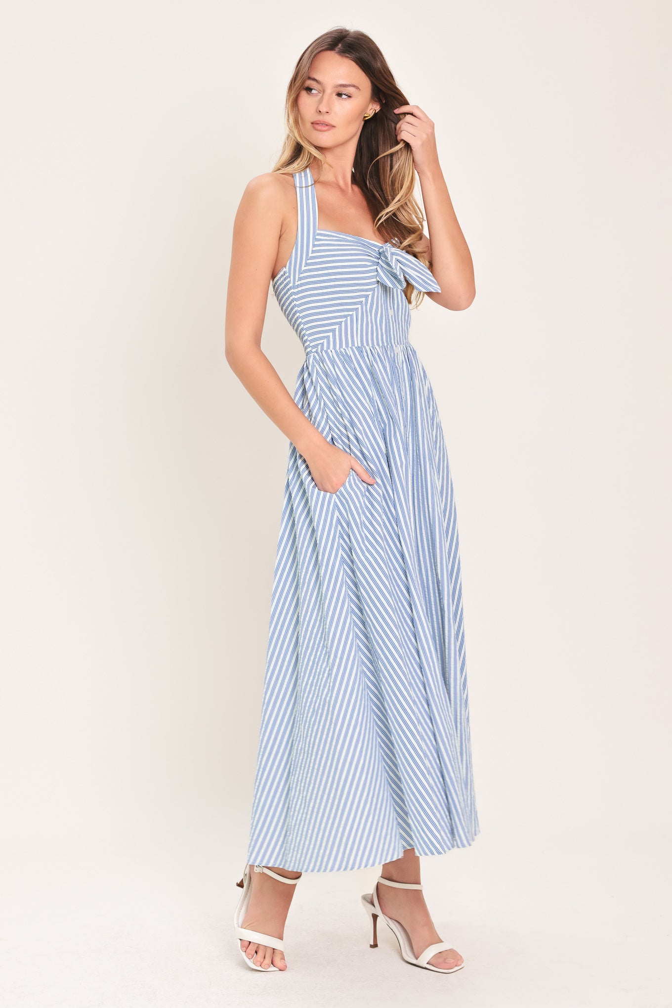 Woman wearing a striped woven midi dress featuring sweetheart halter neckline with back tie, front tie and button down, bare back with smocked back bodice | Flying Tomato