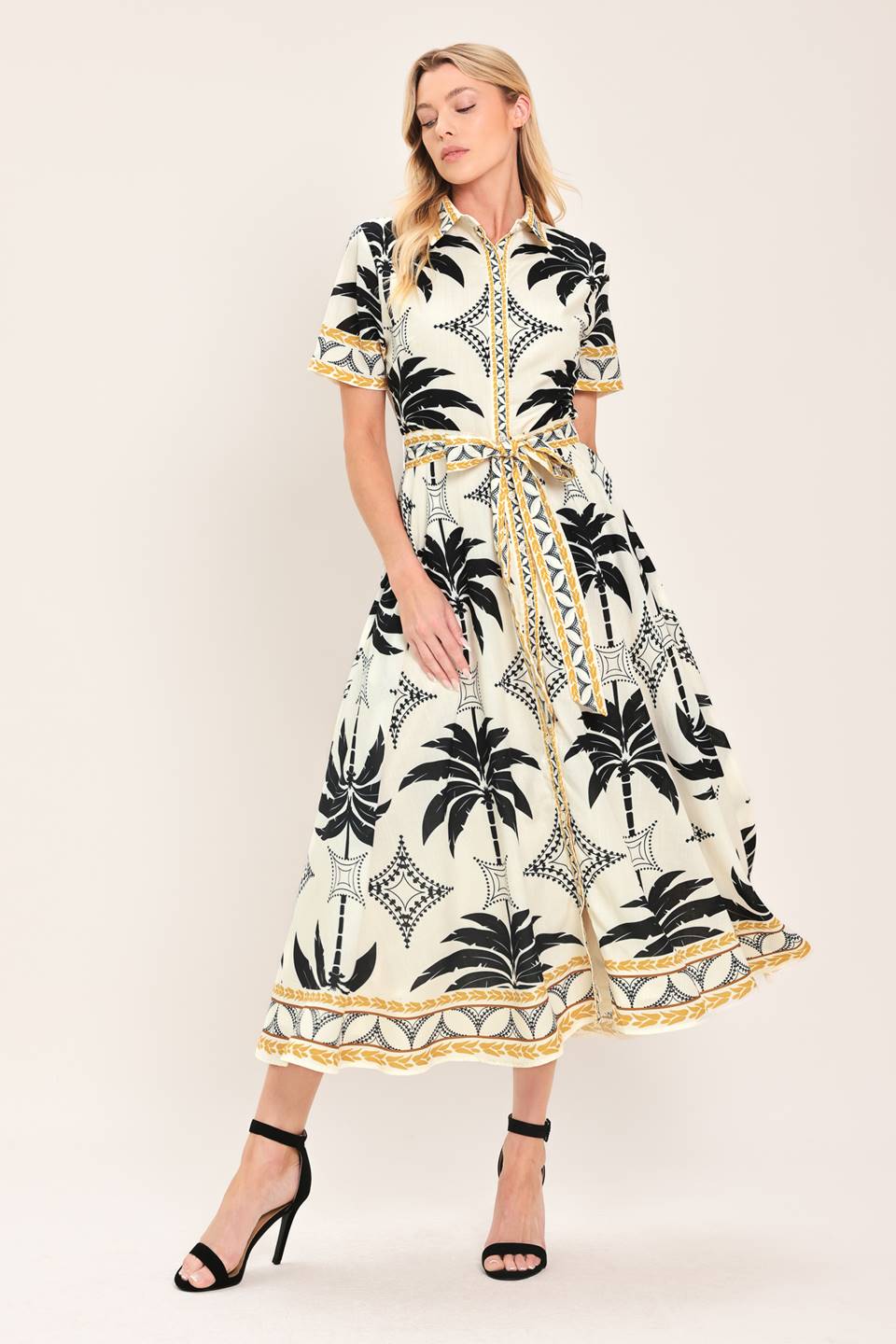 Woman wearing a black and white palm patterned shirt midi dress with short sleeve and self sash tie | Flying Tomato