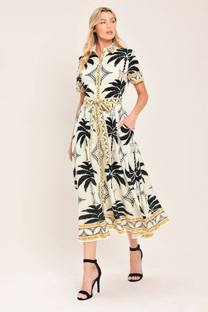 Woman wearing a black and white palm patterned shirt midi dress with short sleeve and self sash tie | Flying Tomato