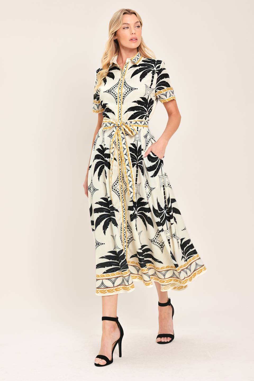Woman wearing a black and white palm patterned shirt midi dress with short sleeve and self sash tie | Flying Tomato