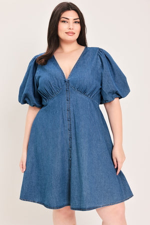 Woman wearing a denim mini dress featuring V neckline, short puff sleeve, button down detail, circle skirt and back zipper closure | Flying Tomato