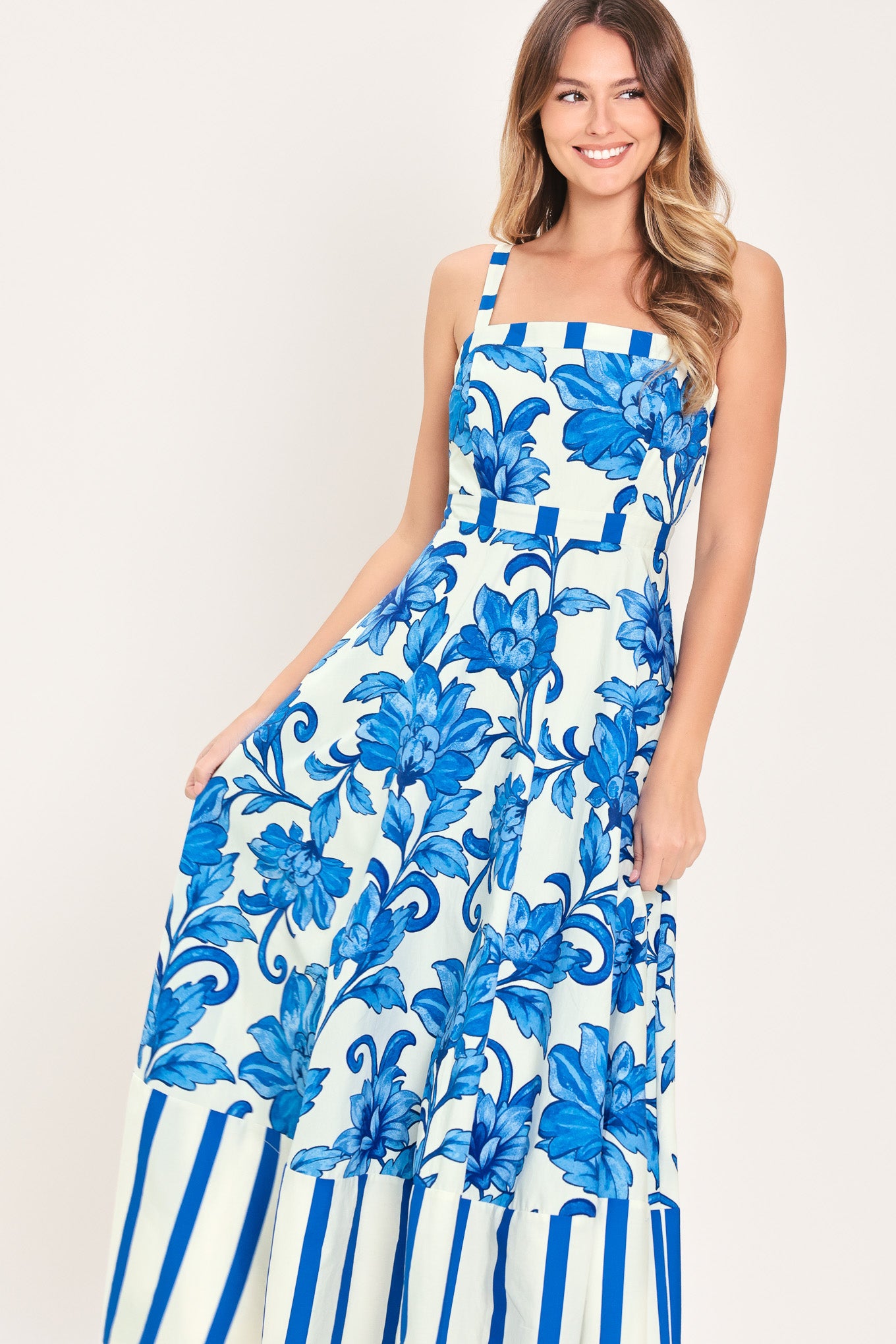 Woman wearing a striped blue and white dress with blue floral pattern on the center | Flying Tomato