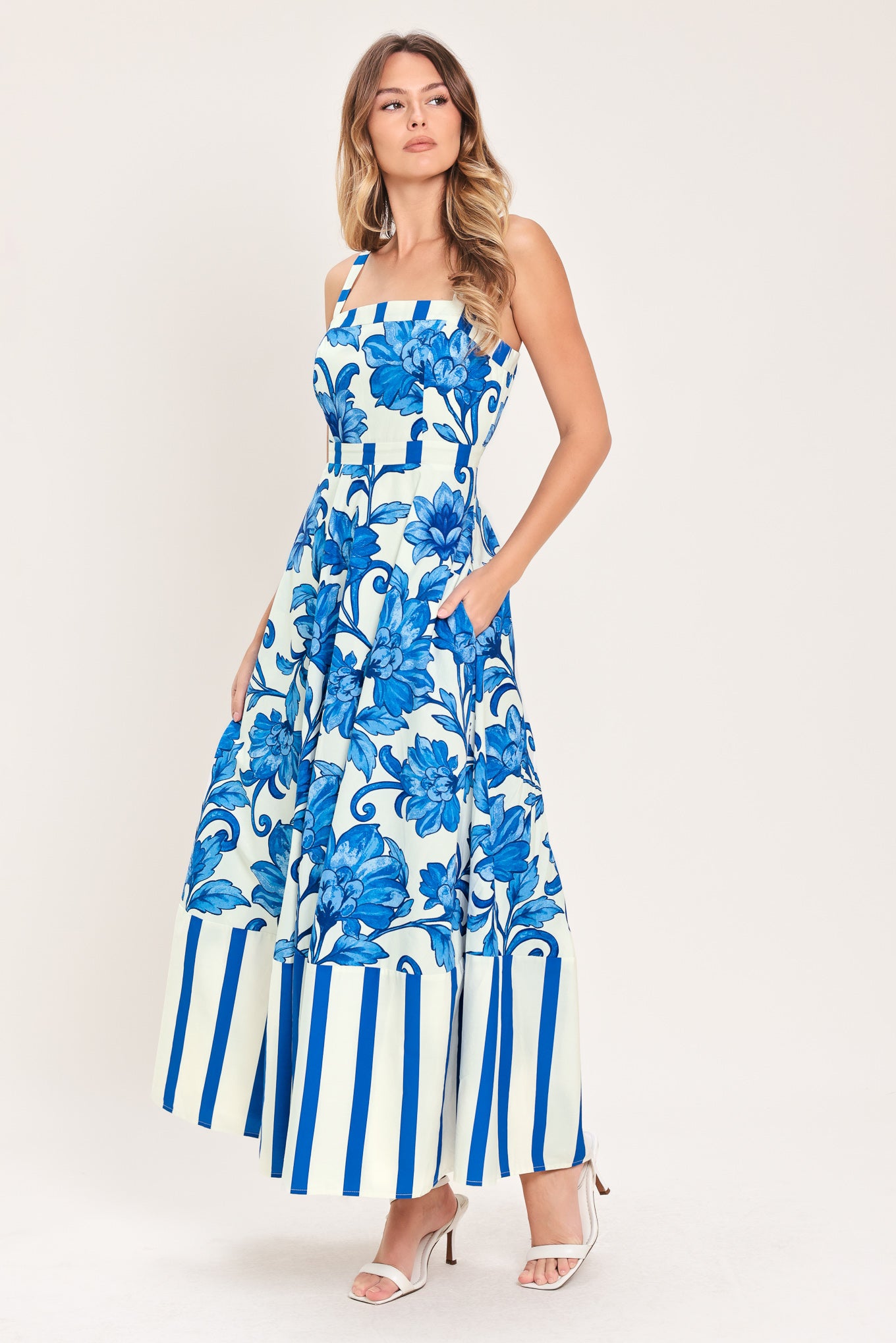 Woman wearing a striped blue and white dress with blue floral pattern on the center | Flying Tomato