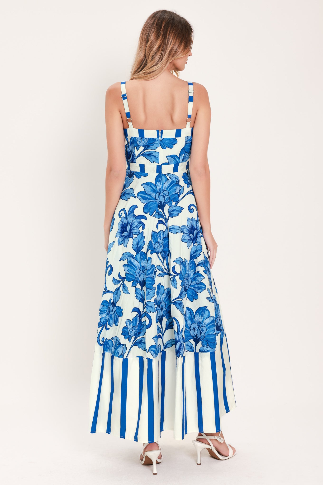 Woman wearing a striped blue and white dress with blue floral pattern on the center | Flying Tomato