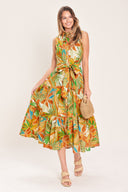 Woman wearing a rust and olive printed woven midi shirt dress featuring sleeveless, button down, self sash and tier skirt | Flying Tomato