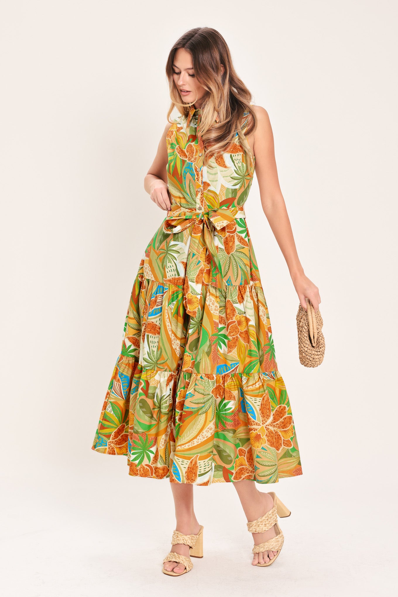 Woman wearing a rust and olive printed woven midi shirt dress featuring sleeveless, button down, self sash and tier skirt | Flying Tomato