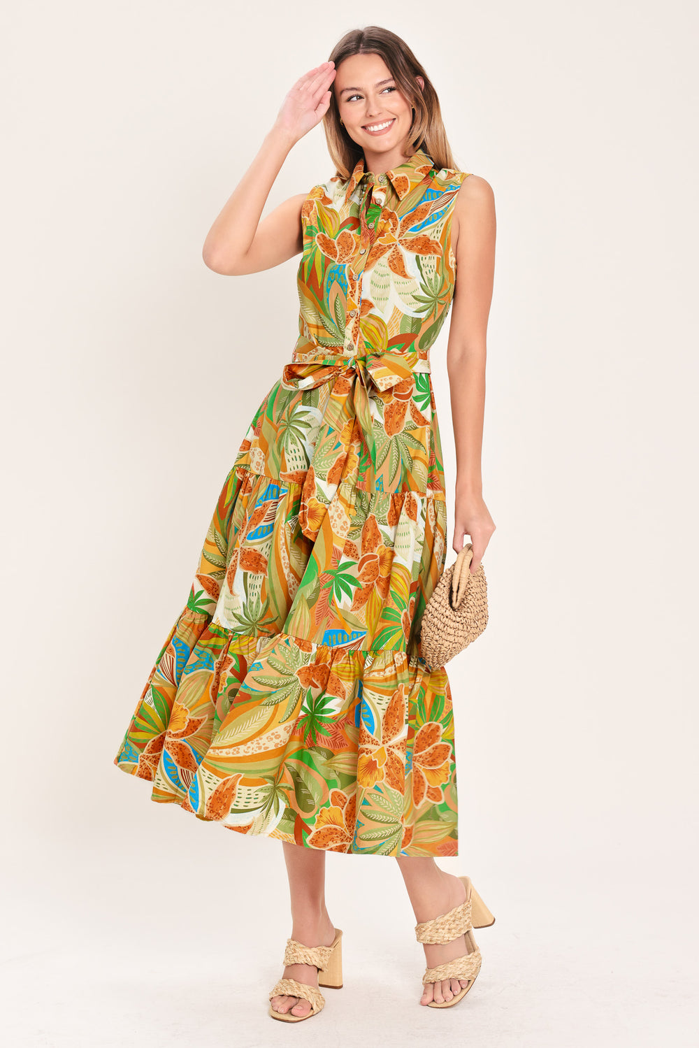 Woman wearing a rust and olive printed woven midi shirt dress featuring sleeveless, button down, self sash and tier skirt | Flying Tomato