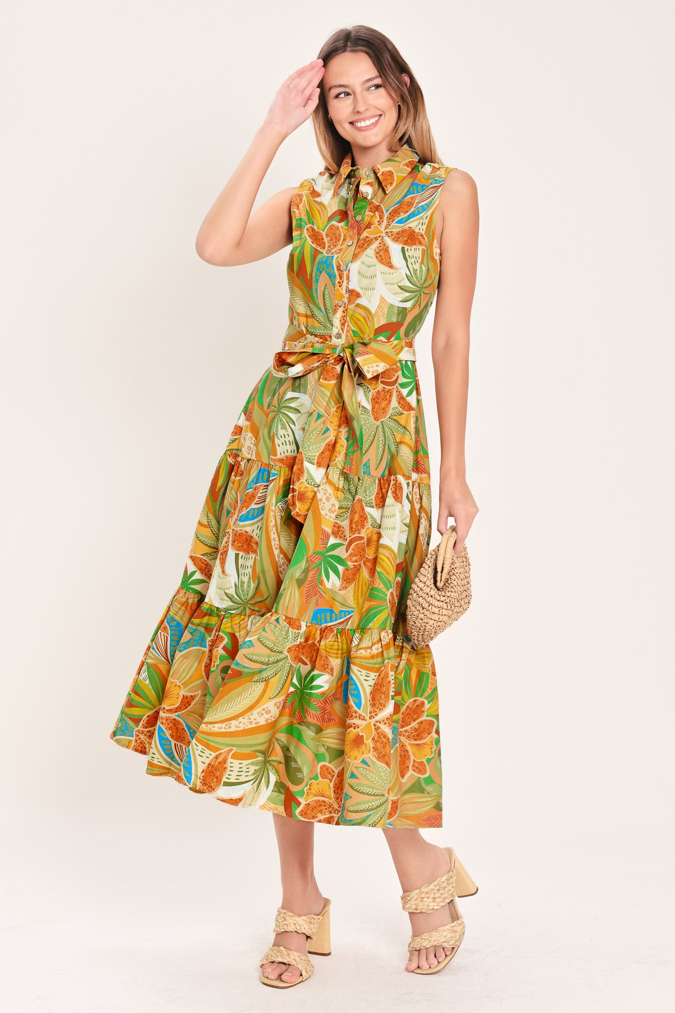 Woman wearing a rust and olive printed woven midi shirt dress featuring sleeveless, button down, self sash and tier skirt | Flying Tomato