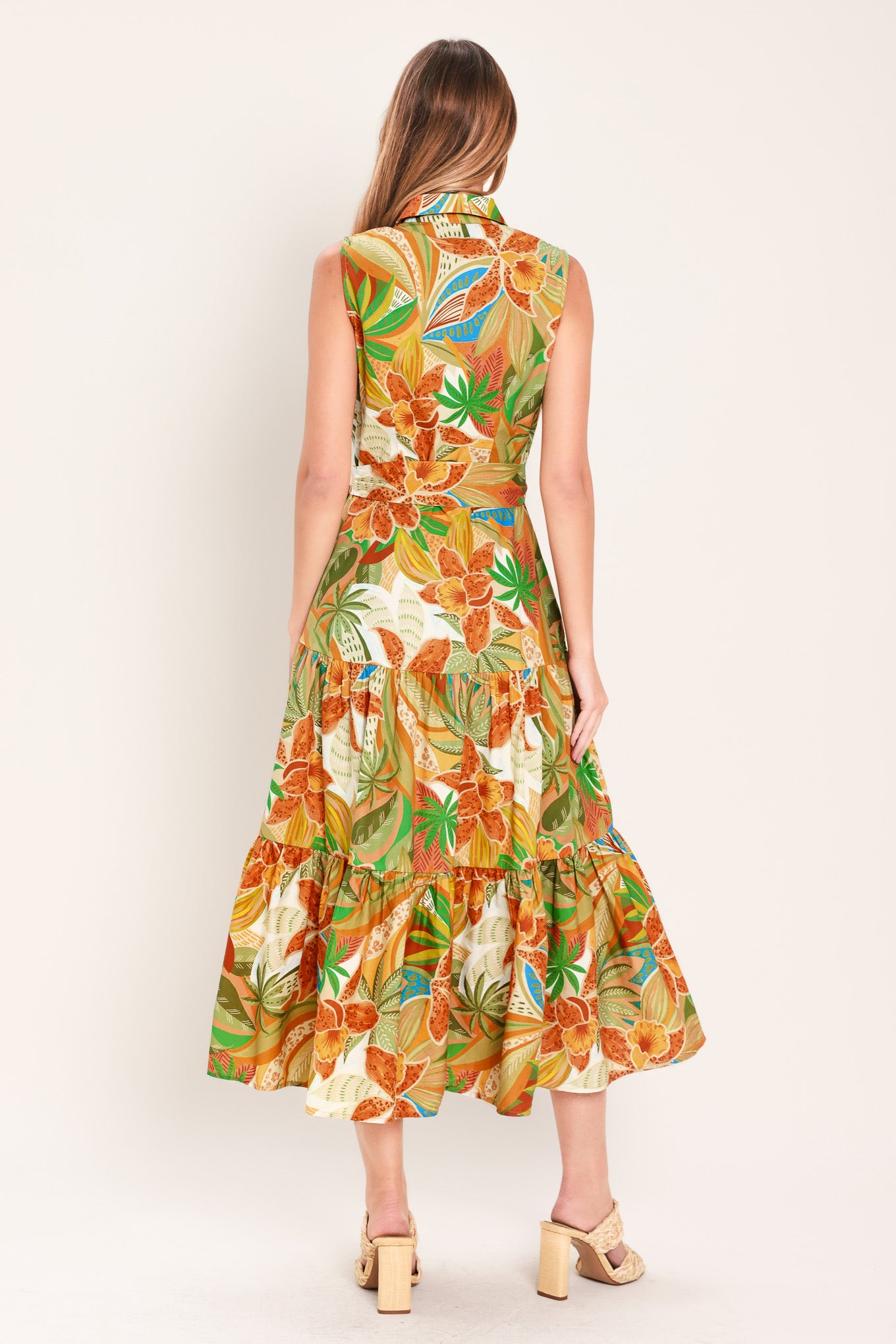 Woman wearing a rust and olive printed woven midi shirt dress featuring sleeveless, button down, self sash and tier skirt | Flying Tomato