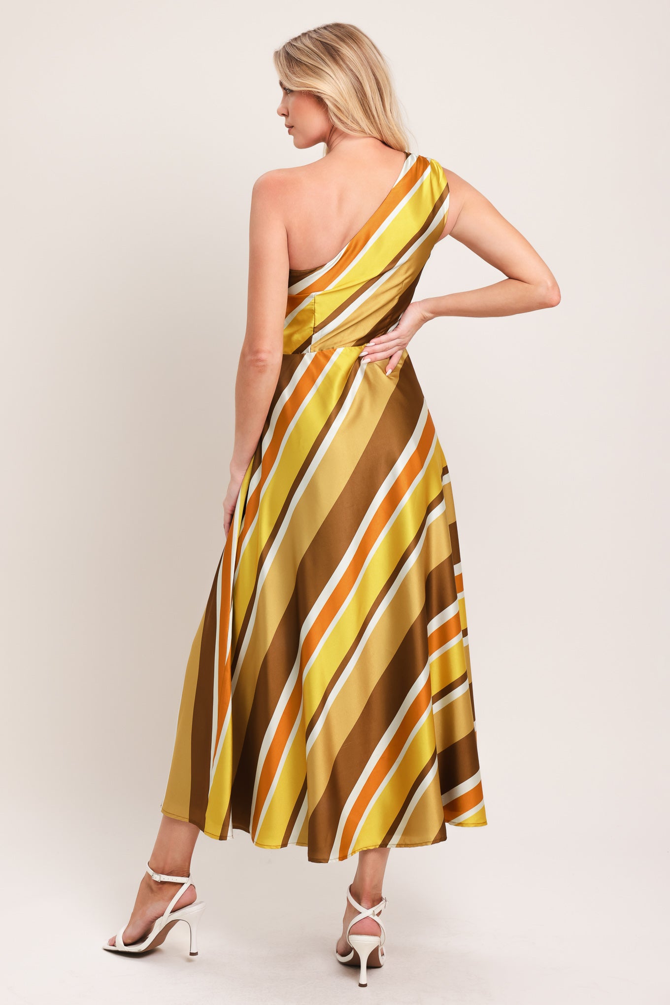 Woman wearing a one-shoulder yellow and brown striped midi dress featuring a side zipper and full circle skirt | Flying Tomato