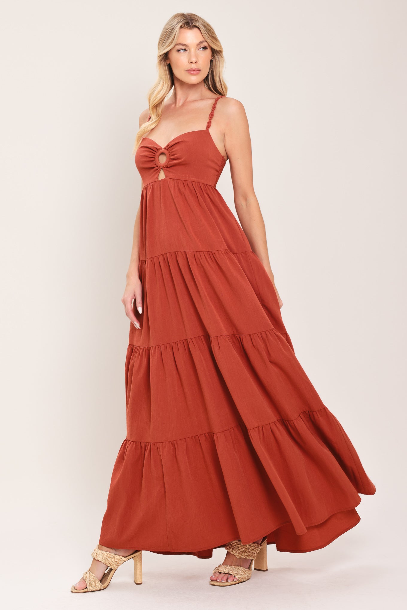 Woman wearing a rust-colored tiered maxi dress featuring cami top with O ring and cut out, lace straps, and smocked back bodice | Flying Tomato