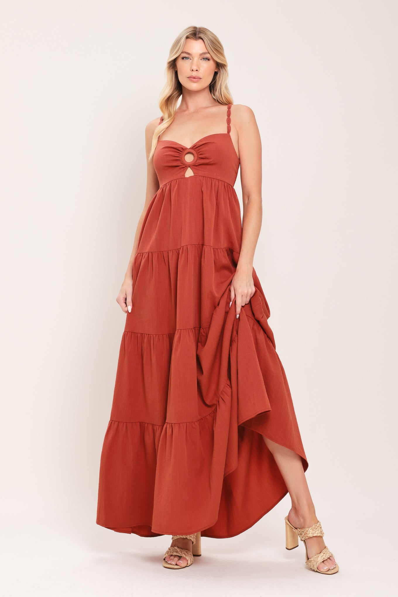 Woman wearing a rust-colored tiered maxi dress featuring cami top with O ring and cut out, lace straps, and smocked back bodice | Flying Tomato