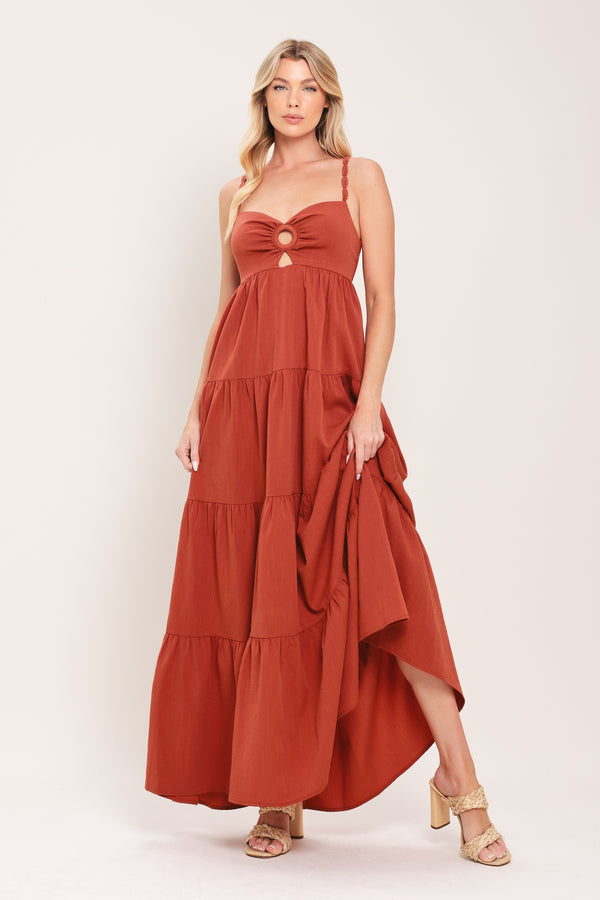 Woman wearing a rust-colored tiered maxi dress featuring cami top with O ring and cut out, lace straps, and smocked back bodice | Flying Tomato