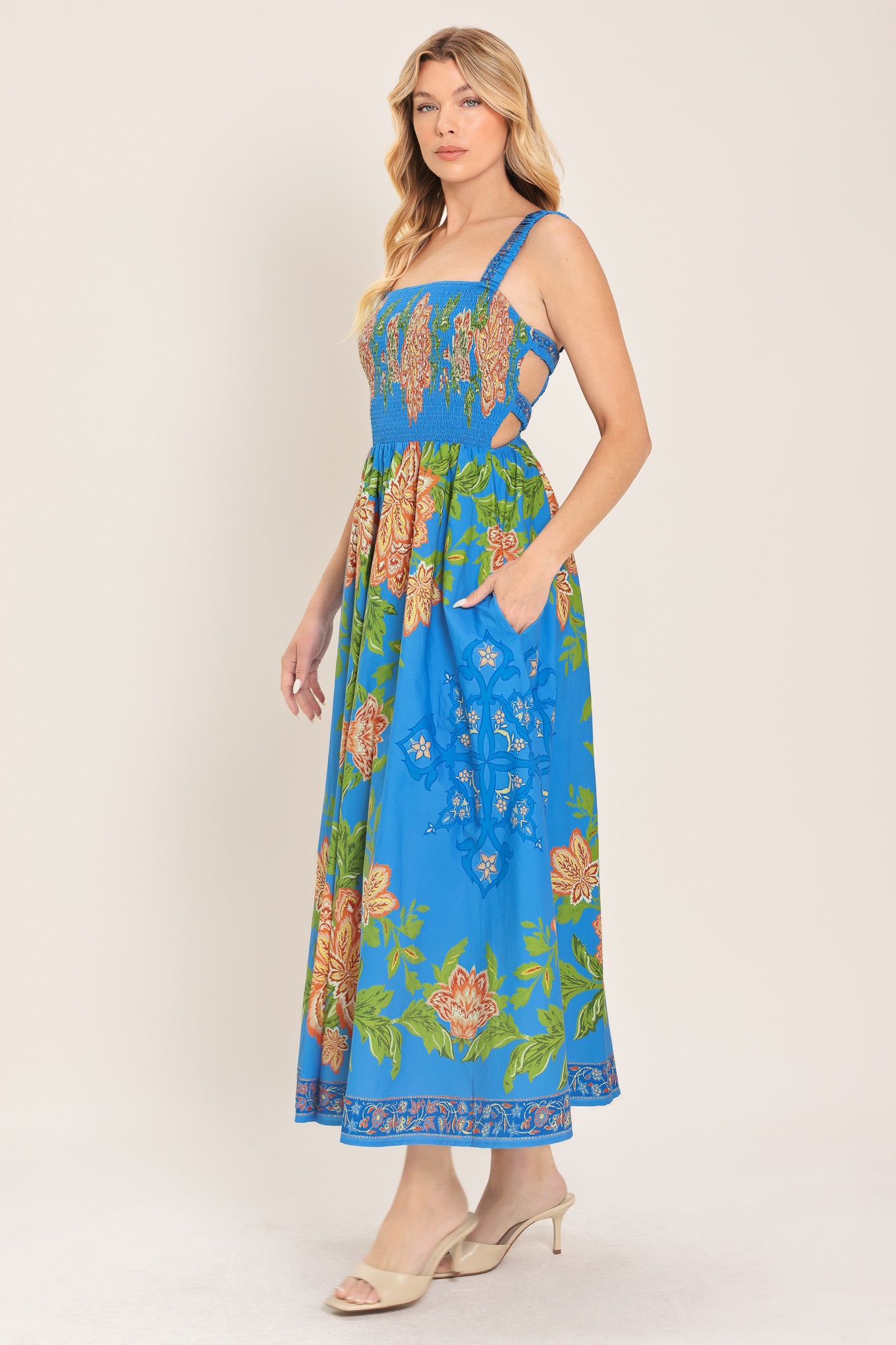 Woman wearing a blue floral midi dress with coral flowers and green leaves and geometric detail | Flying Tomato
