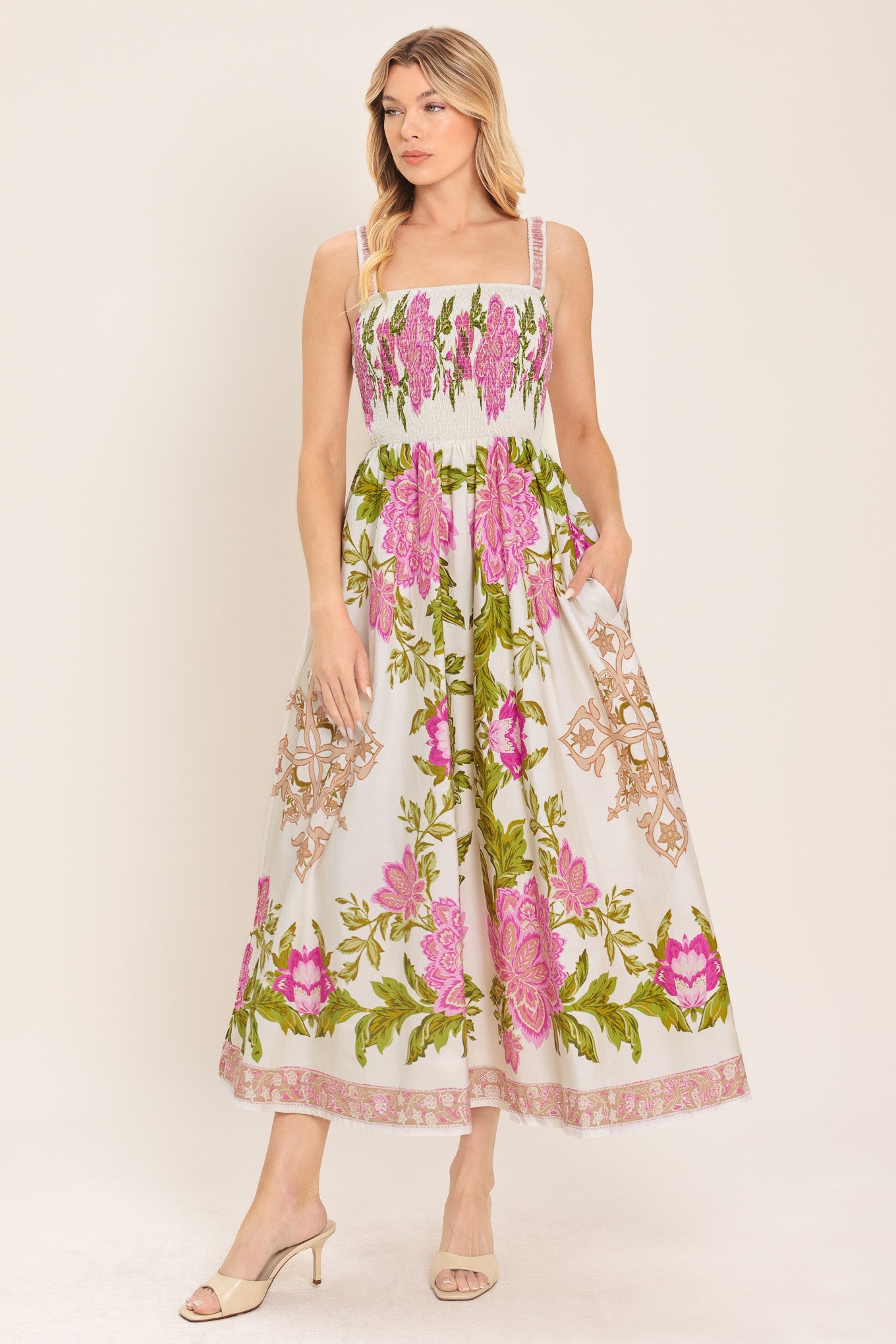 Woman wearing an ivory floral midi dress with pink flowers and green leaves and geometric detail | Flying Tomato