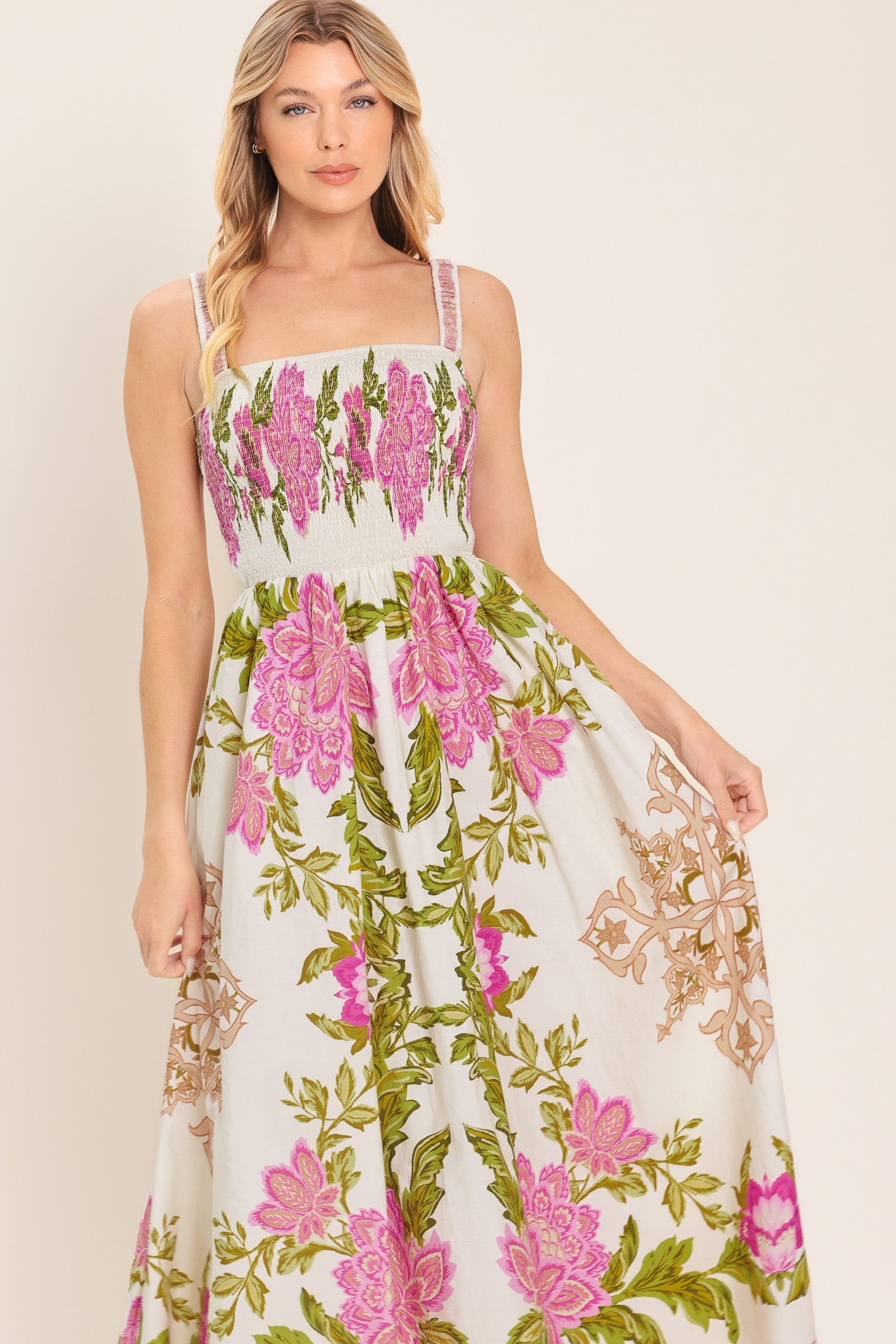 Woman wearing a floral midi dress with pink flowers and green leaves and geometric detail | Flying Tomato