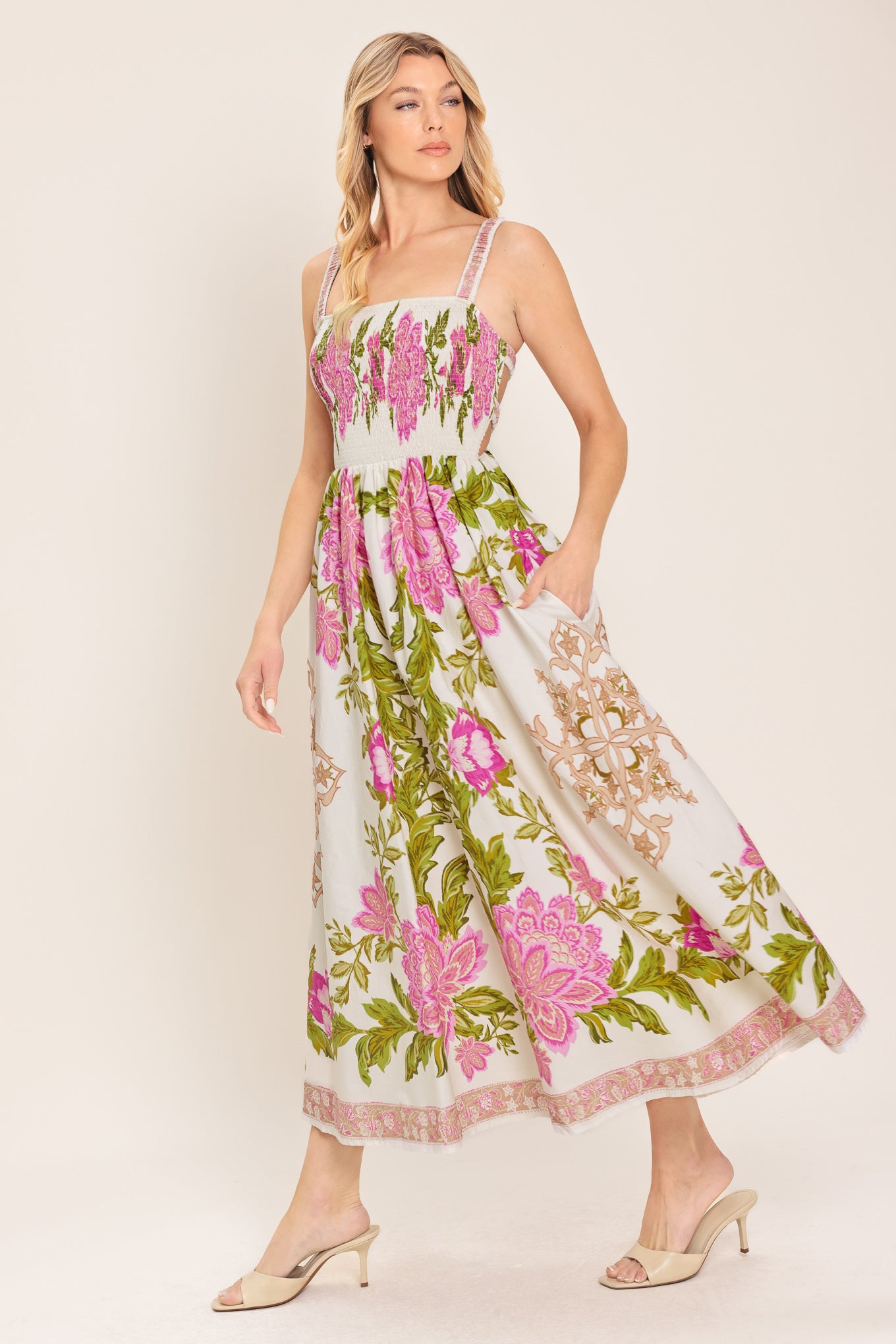 Woman wearing an ivory floral midi dress with pink flowers and green leaves and geometric detail | Flying Tomato
