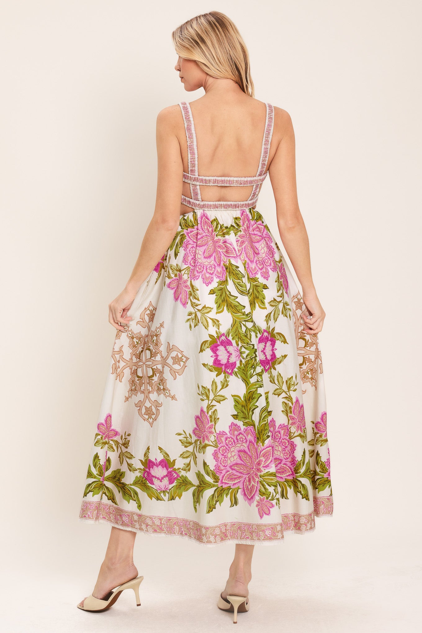 Woman wearing an ivory floral midi dress with pink flowers and green leaves and geometric detail | Flying Tomato