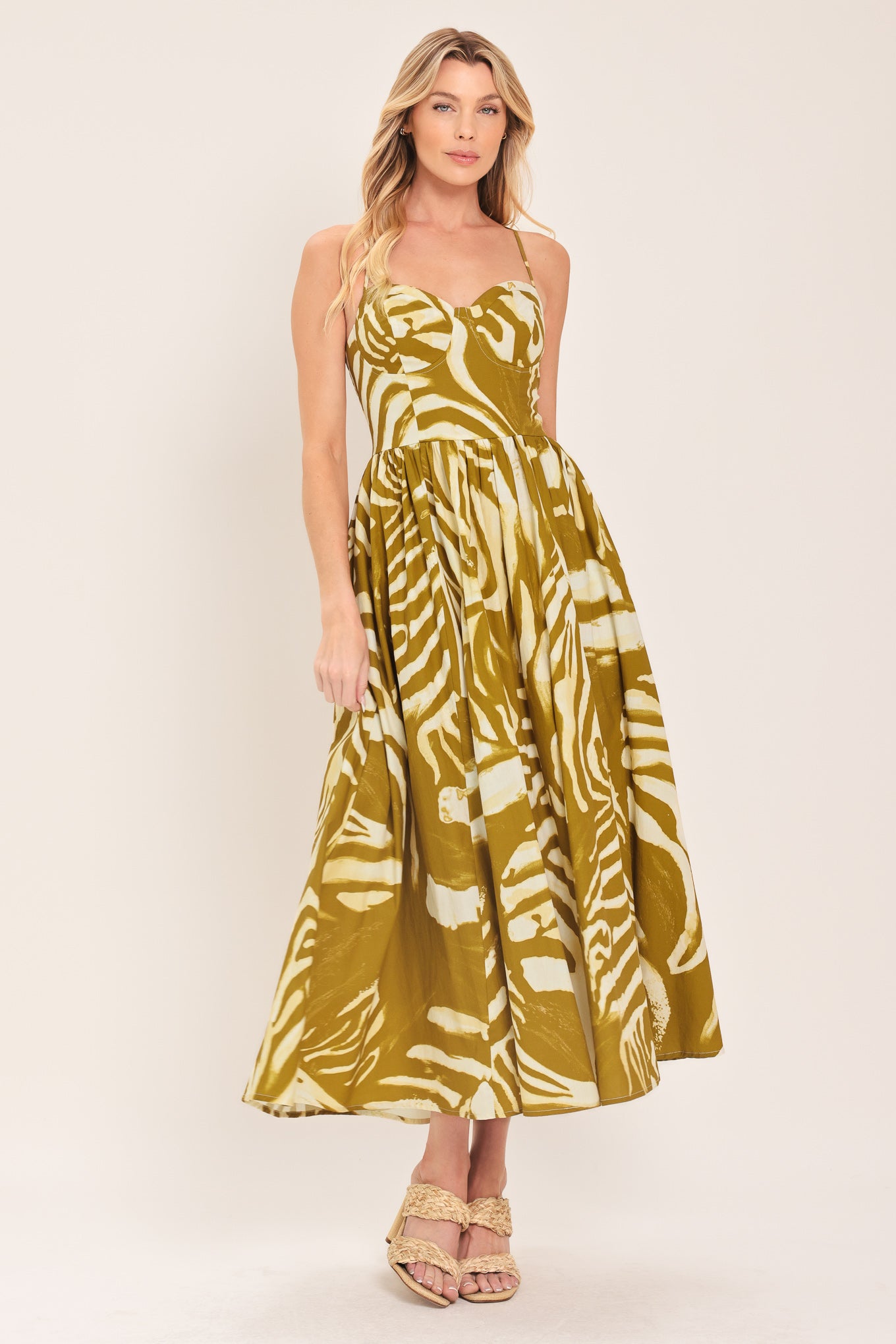 Woman wearing a mustard yellow and white patterned midi dress featuring bustier top, full skirt, bare back with lace up tie and zipper closure | Flying Tomato