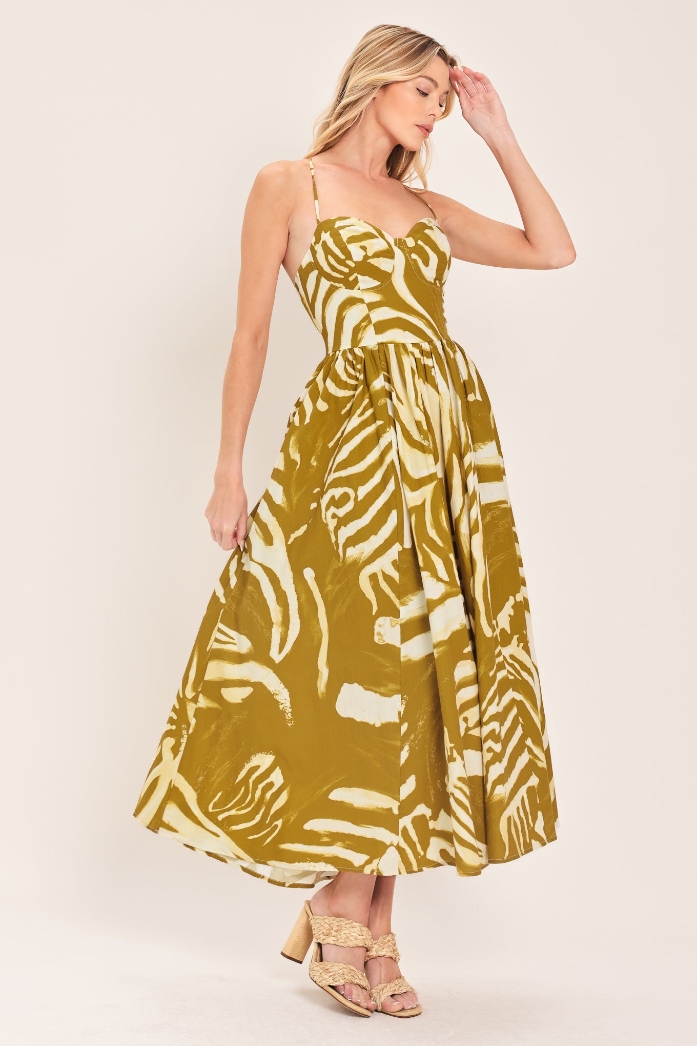 Woman wearing a mustard yellow and white patterned midi dress featuring bustier top, full skirt, bare back with lace up tie and zipper closure | Flying Tomato