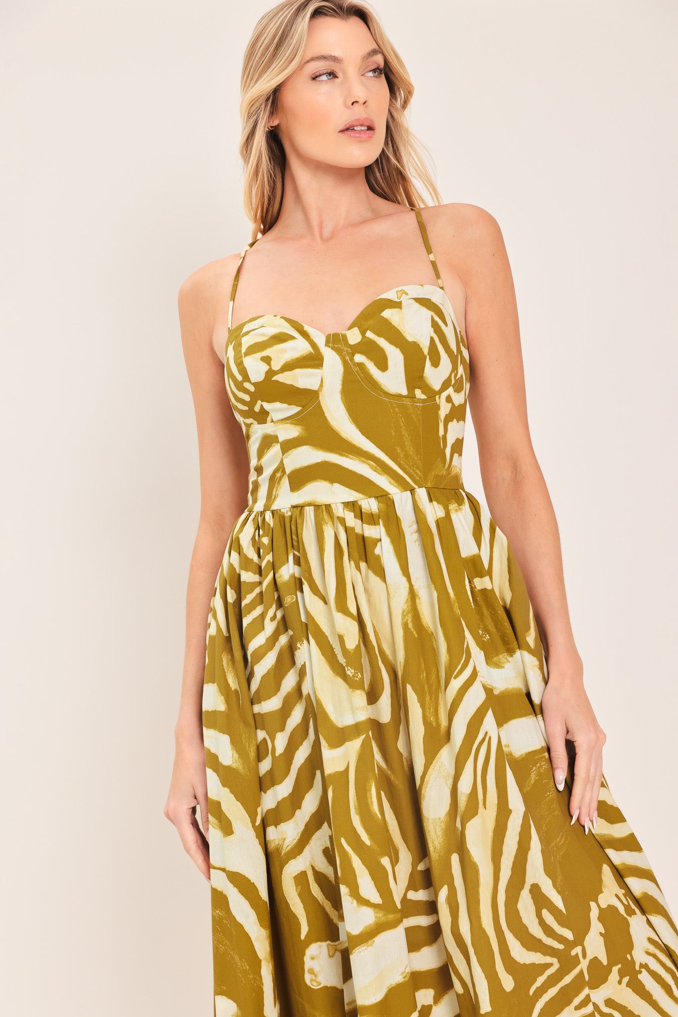 Woman wearing a mustard yellow and white patterned midi dress featuring bustier top, full skirt, bare back with lace up tie and zipper closure | Flying Tomato