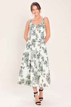 Woman wearing a black and white floral midi dress featuring sweetheart neckline, straps, circle skirt and back zipper closure | Flying Tomato