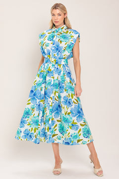 Woman wearing a blue, green, and teal floral midi dress featuring collar, drop shoulder, button down closure, self belt and full skirt | Flying Tomato