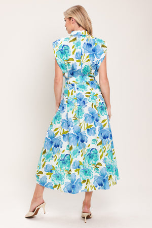 Woman wearing a blue, green, and teal floral midi dress featuring collar, drop shoulder, button down closure, self belt and full skirt | Flying Tomato