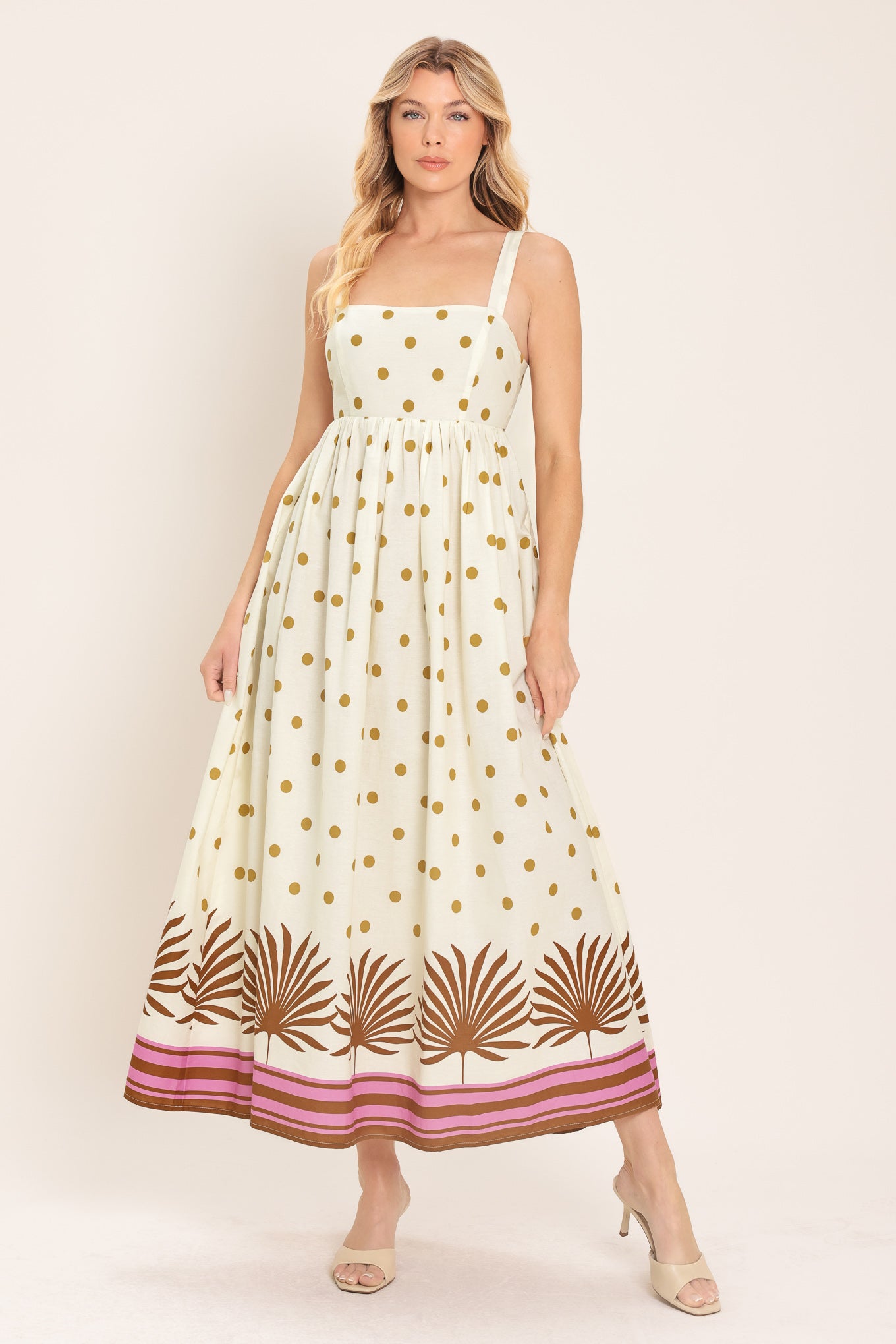 Woman wearing a white midi dress with gold polka dots and brown leaf patterns | Flying Tomato
