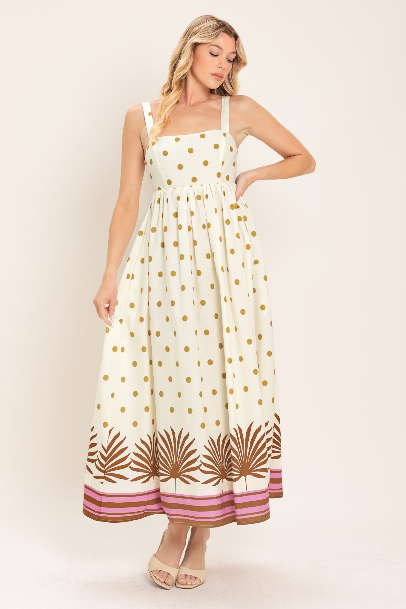 Woman wearing a white midi dress with gold polka dots and brown leaf patterns | Flying Tomato