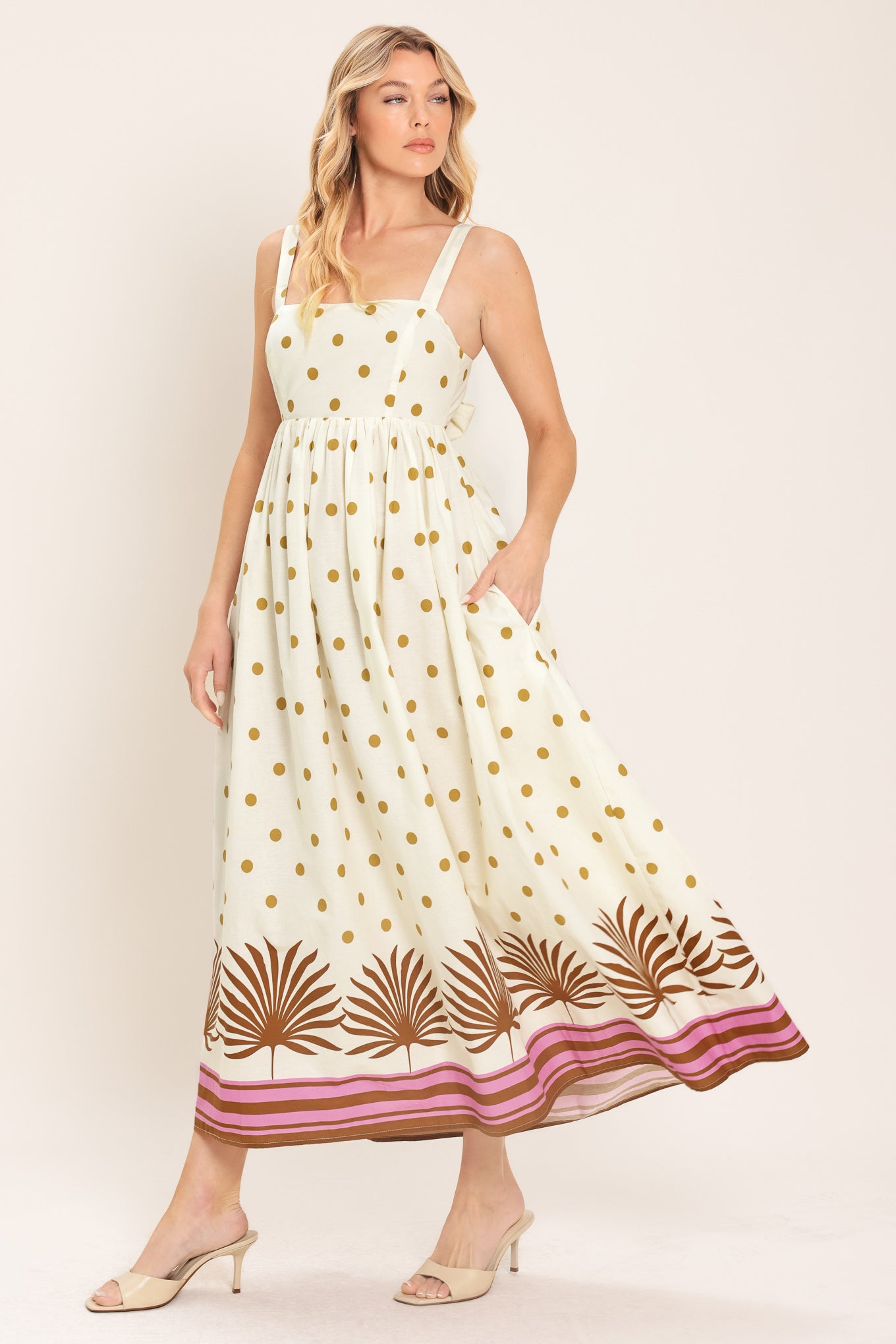Woman wearing a white midi dress with gold polka dots and brown leaf patterns | Flying Tomato