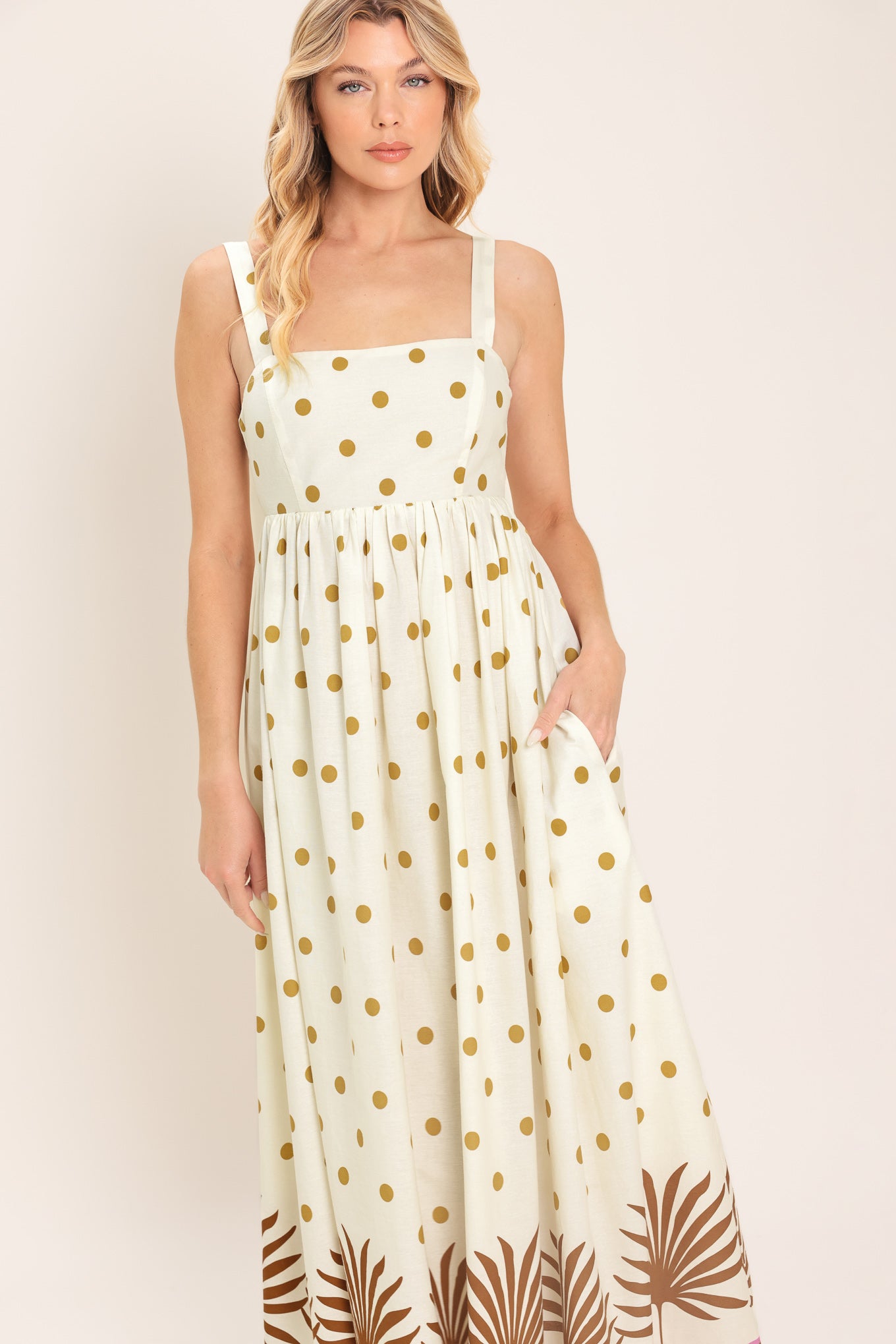 Woman wearing a white midi dress with gold polka dots and brown leaf patterns | Flying Tomato
