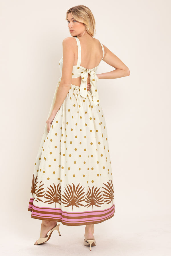 Woman wearing a white midi dress with gold polka dots and brown leaf patterns | Flying Tomato