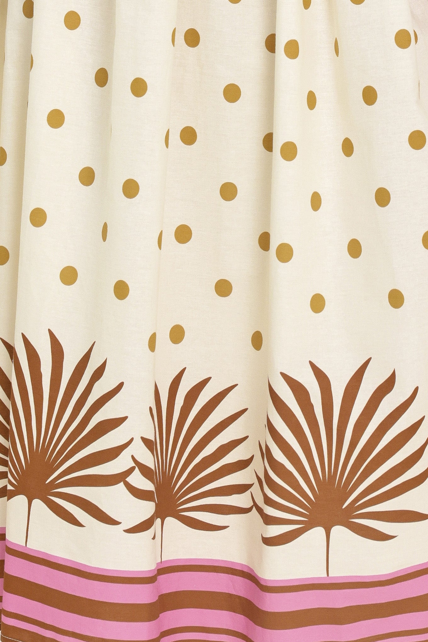 Woman wearing a white midi dress with gold polka dots and brown leaf patterns | Flying Tomato