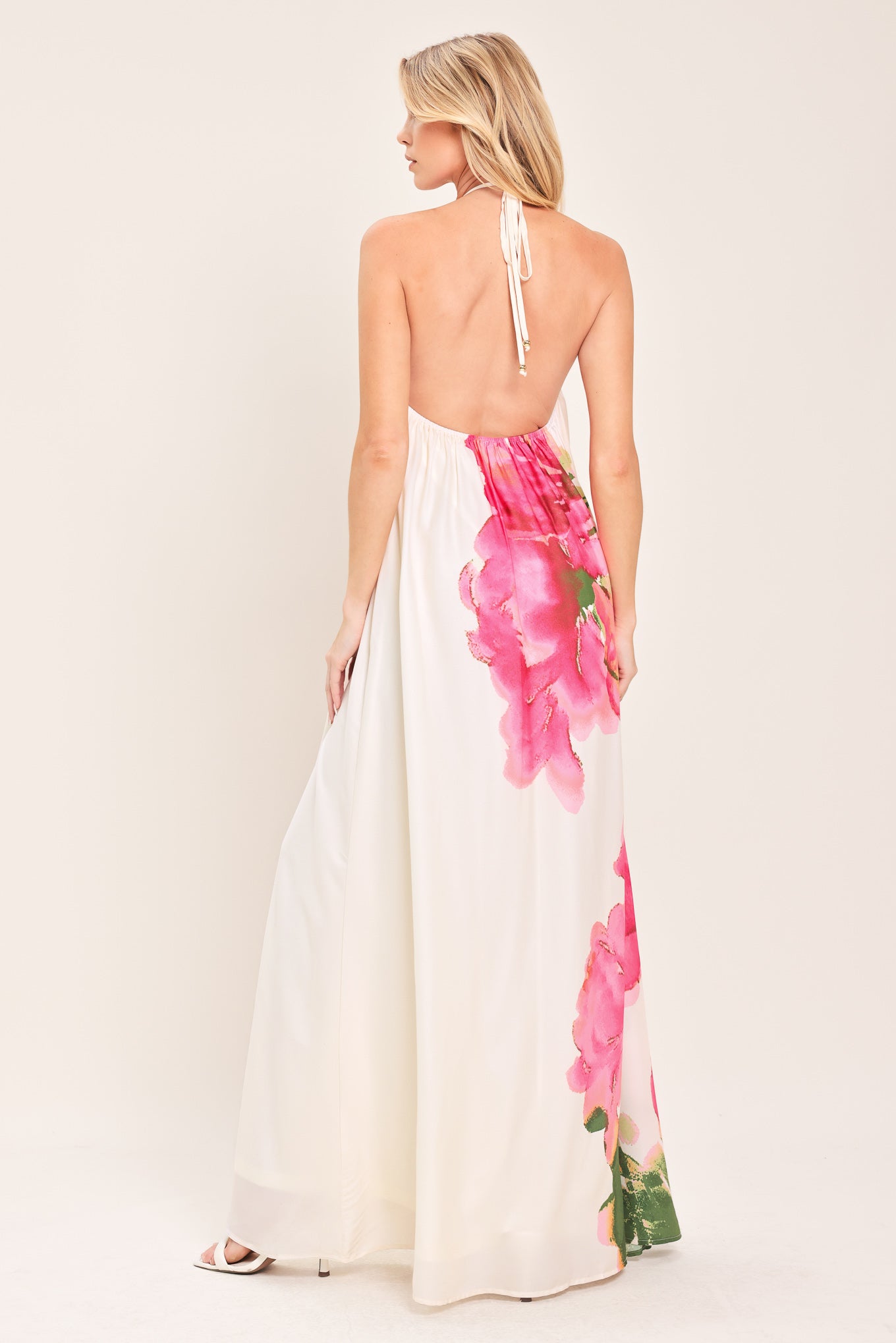 Woman wearing a floral maxi dress featuring halter neckline, bare back with tie | Flying Tomato