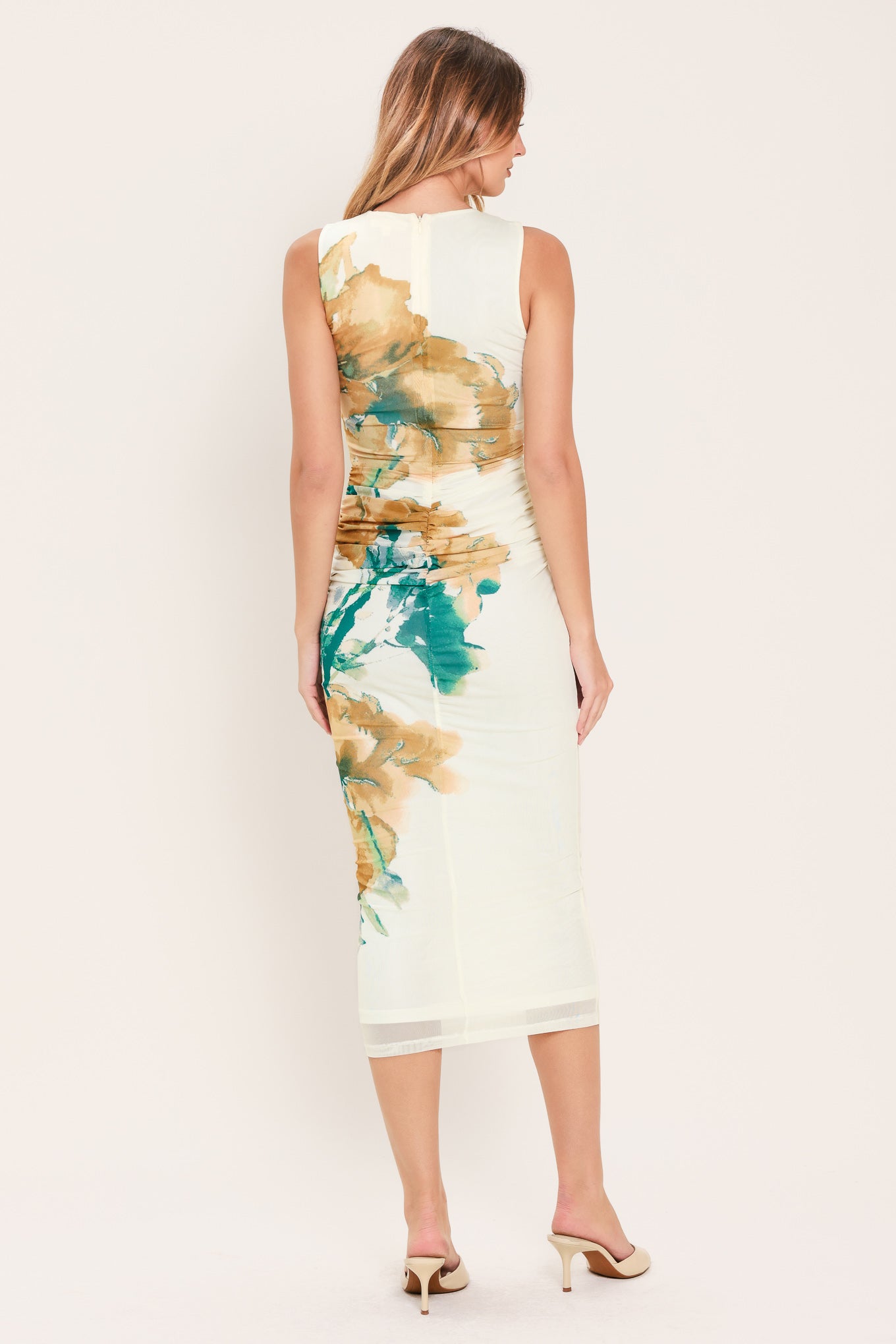 Woman wearing a sleeveless, shirred body power mesh midi dress with camel and green floral patterns | Flying Tomato
