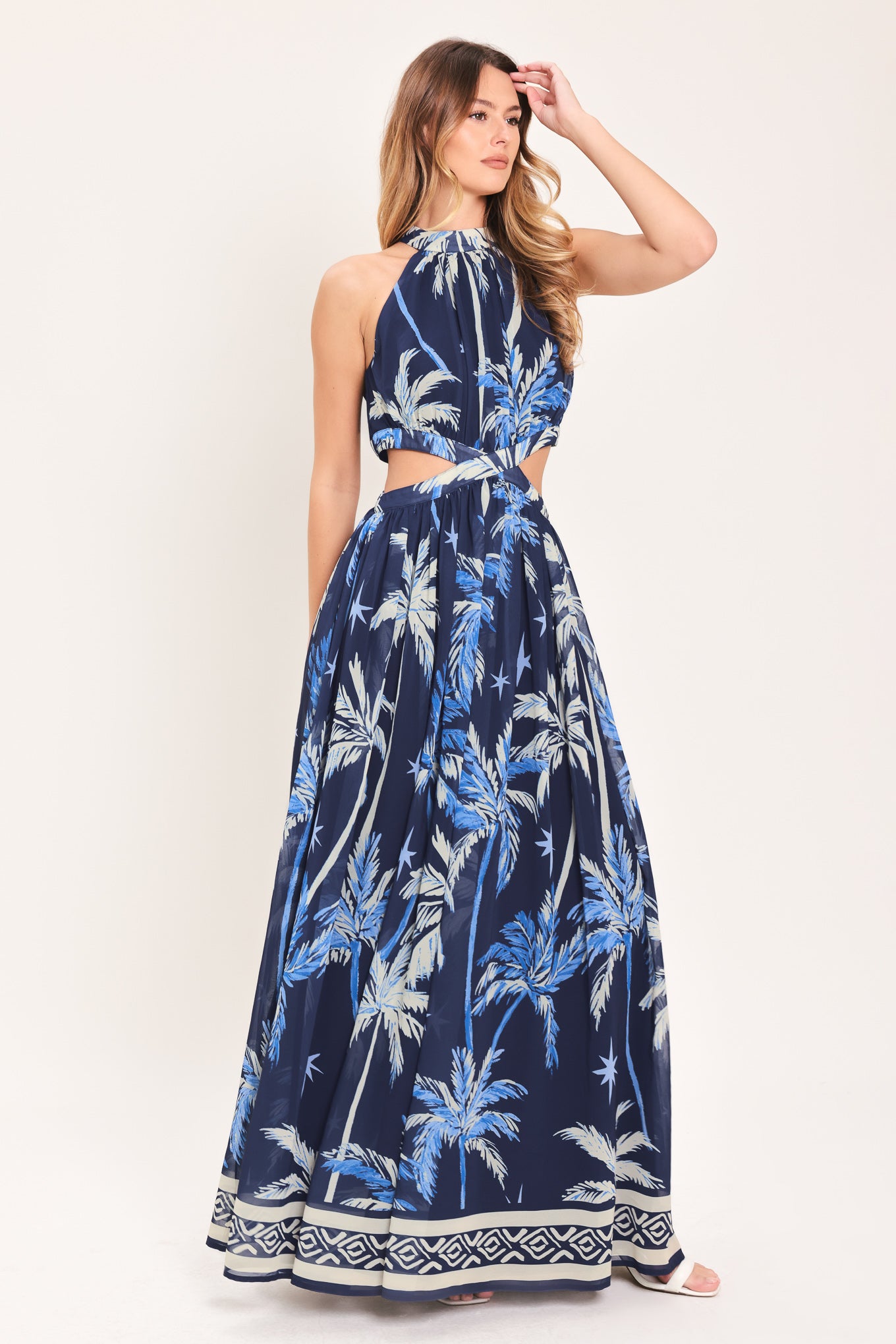 Woman wearing a blue and navy tropical patterned dress with palm trees | Flying Tomato