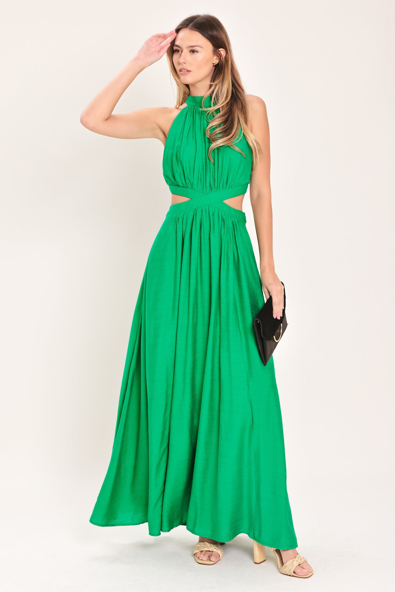 Woman wearing a green maxi dress featuring halter neckline, side cut out and back button/zipper closure | Flying Tomato