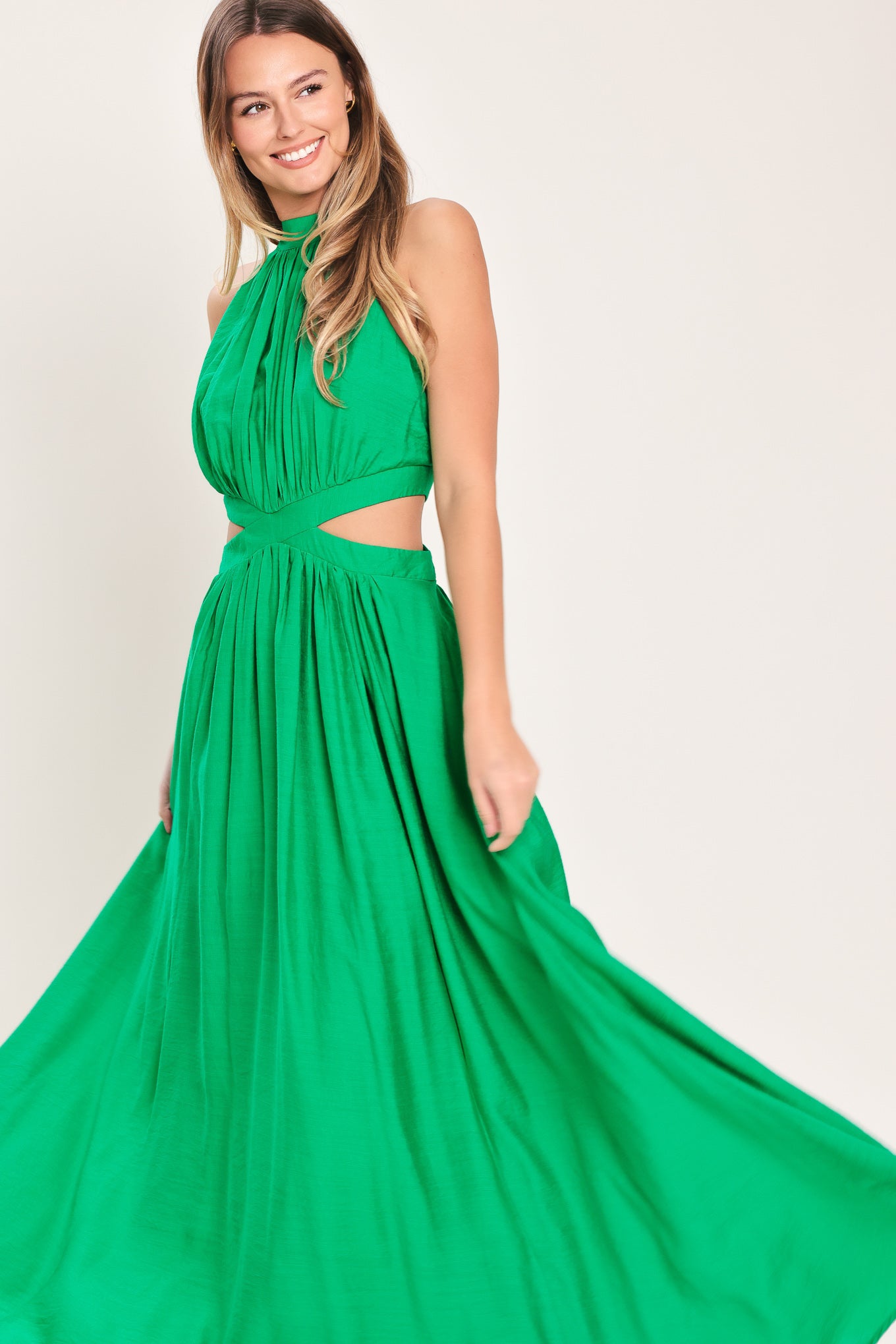 Woman wearing a green maxi dress featuring halter neckline, side cut out and back button/zipper closure | Flying Tomato