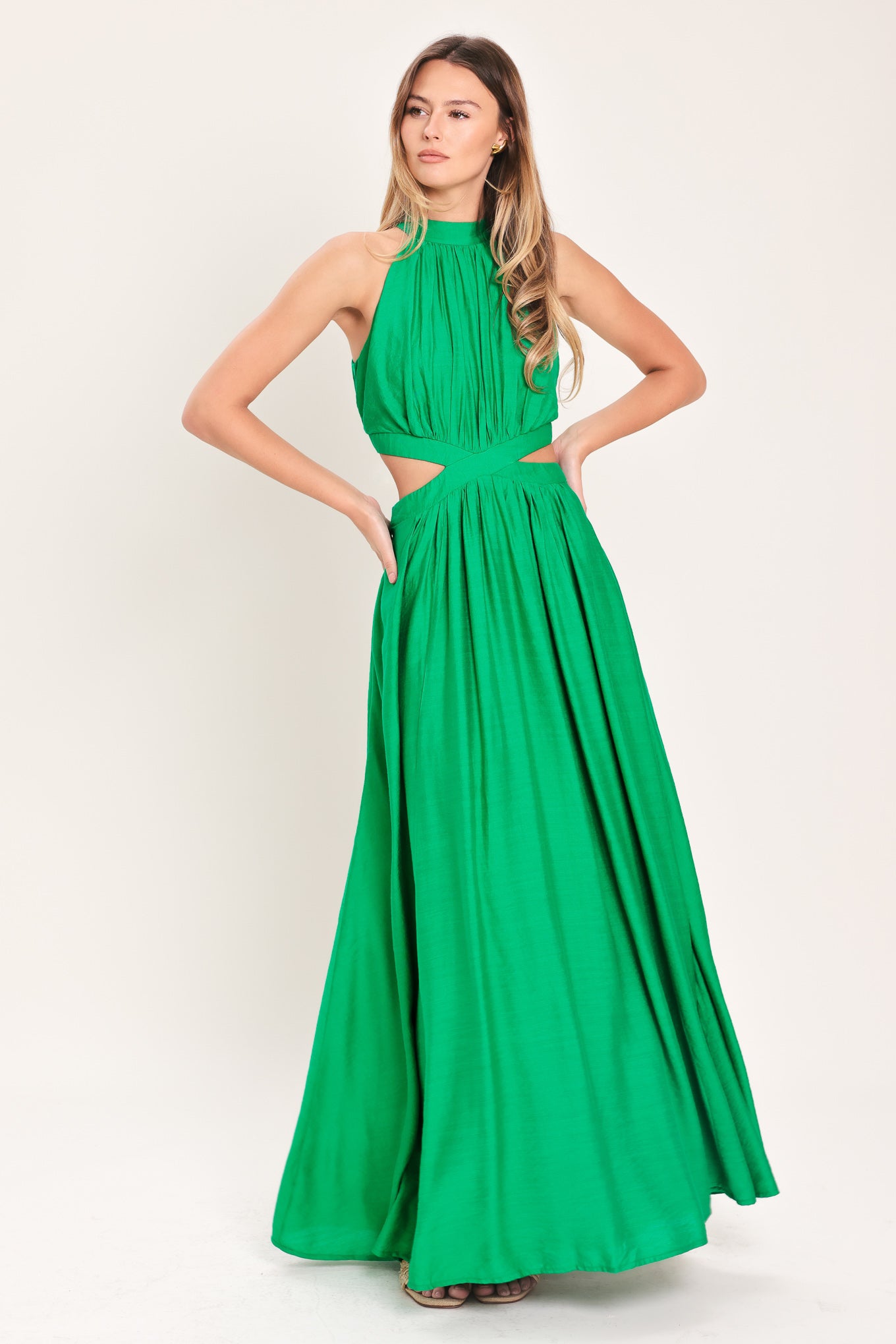 Woman wearing a green maxi dress featuring halter neckline, side cut out and back button/zipper closure | Flying Tomato